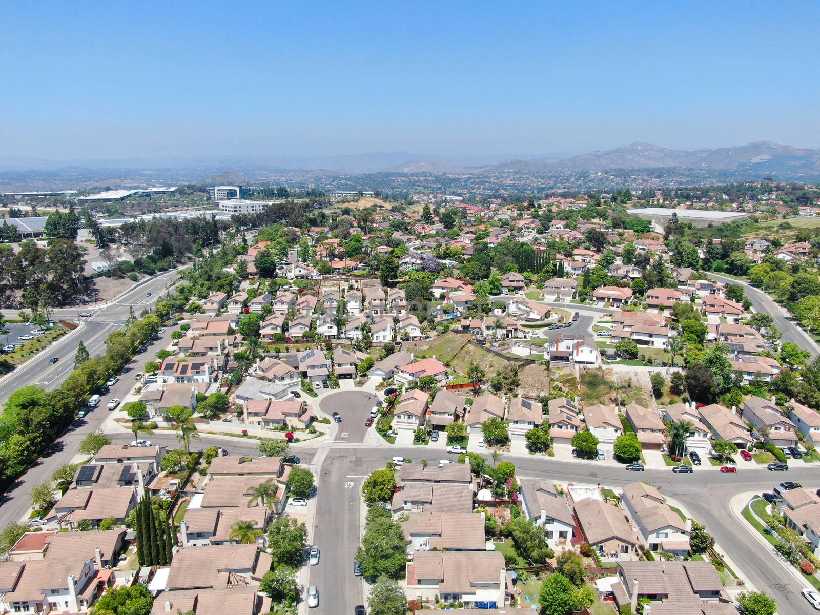 Aerial view of middle class neighborhood with residential house with swimming pool and mountain on the background in Rancho Bernardo, South California, USA.