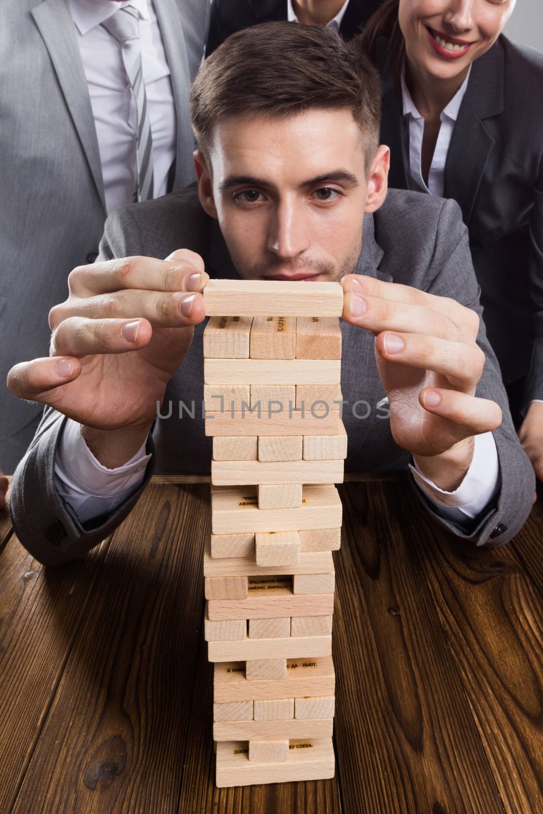 Business people team building wood puzzle tower cooperation concept