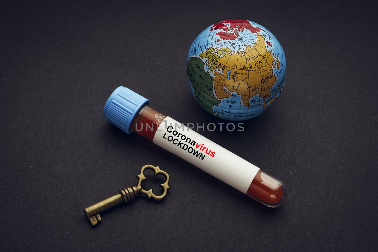 CORONAVIRUS LOCKDOWN text with world globe, key and Blood test vacuum tube on black background by silverwings
