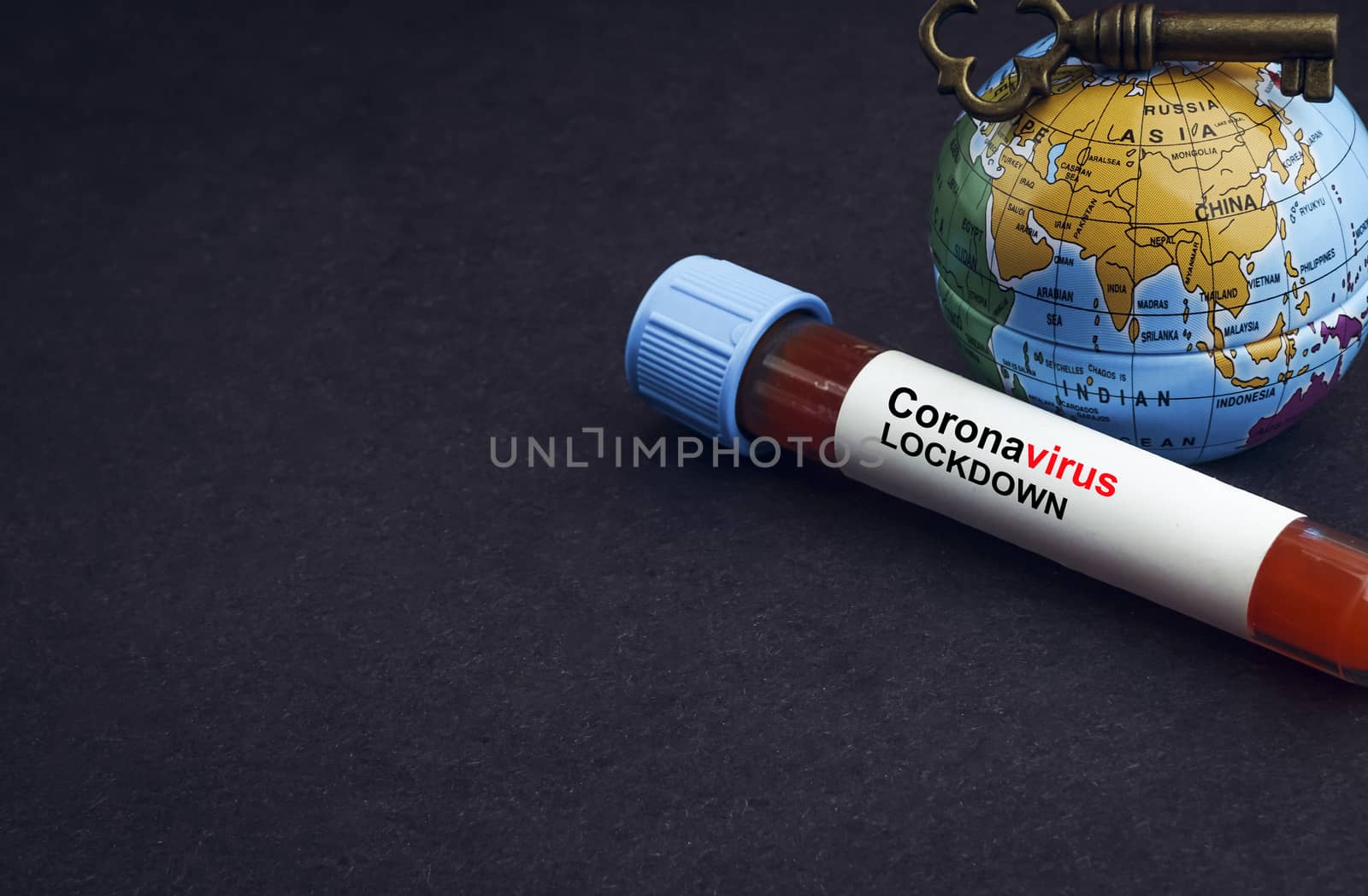 CORONAVIRUS LOCKDOWN text with world globe, key and Blood test vacuum tube on black background by silverwings