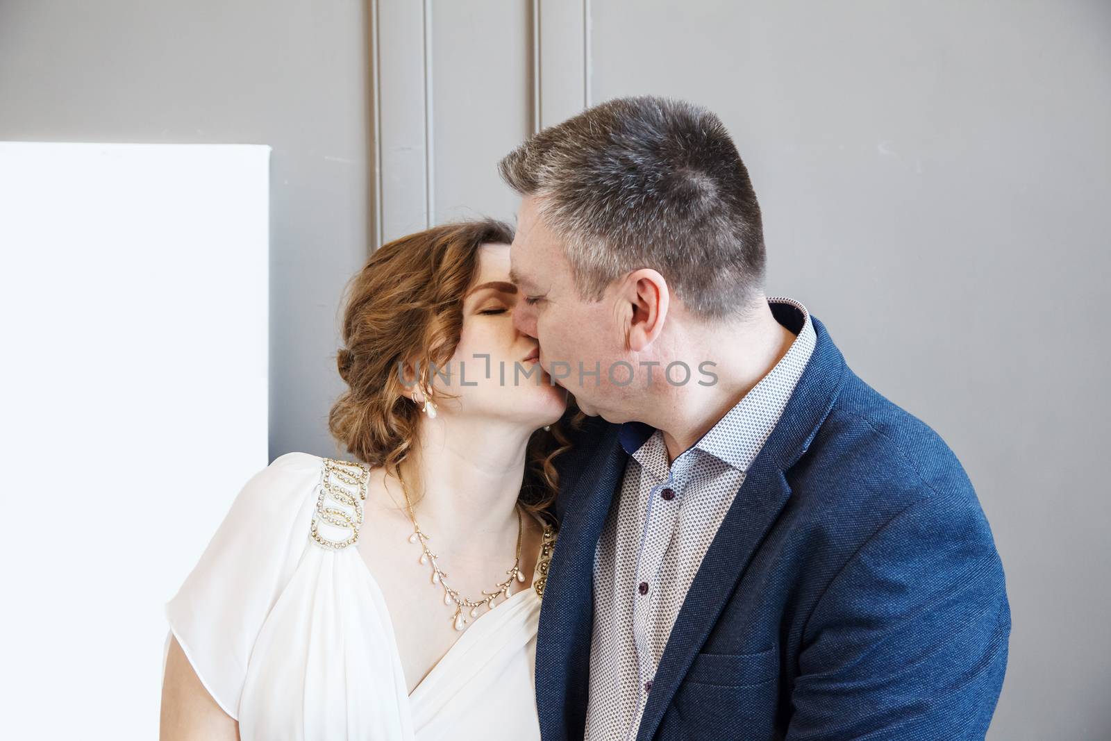 couple of newlyweds kissing indoor with daylight