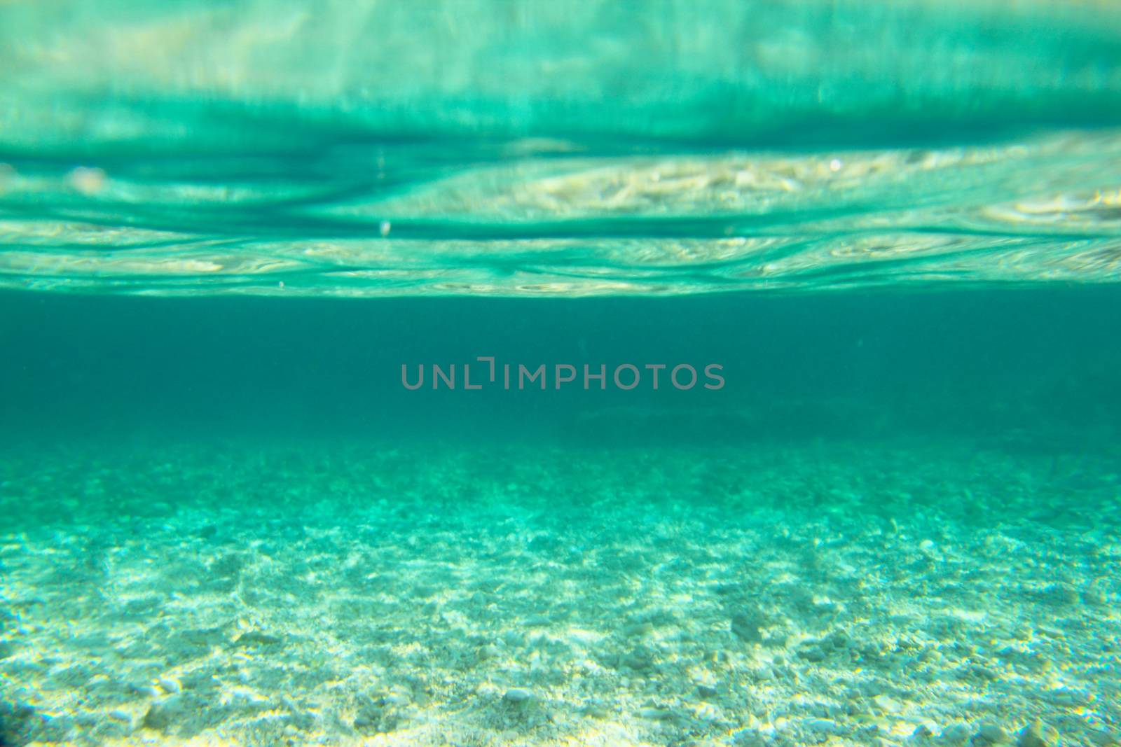 Underwater sea view background of transparent clear water, sea bottom and surface from below