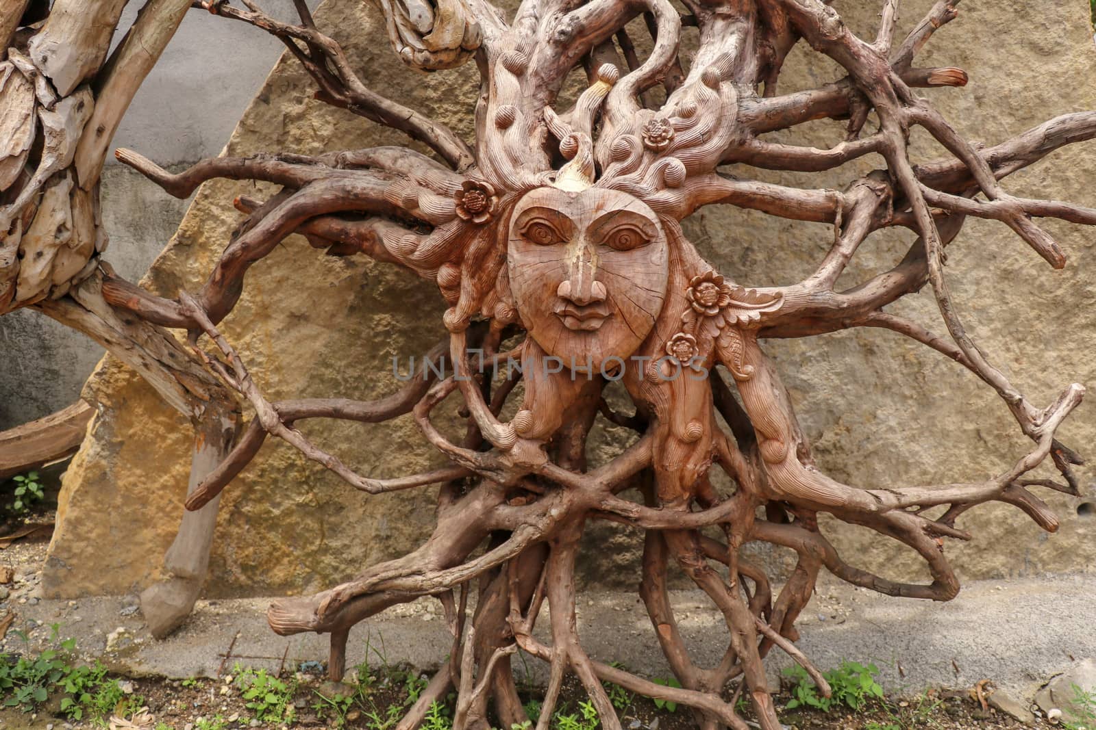 Sun with face made of tree root. Wooden decoration. Dried fibrous roots that spread beautifully to the soil surface. can be used as a background template.Art and work of Balinese artists. Ubud, Bali.