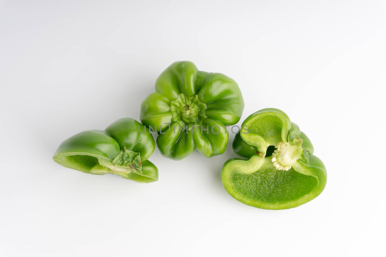 Fresh green bell peppers (capsicum) on a white background by silverwings