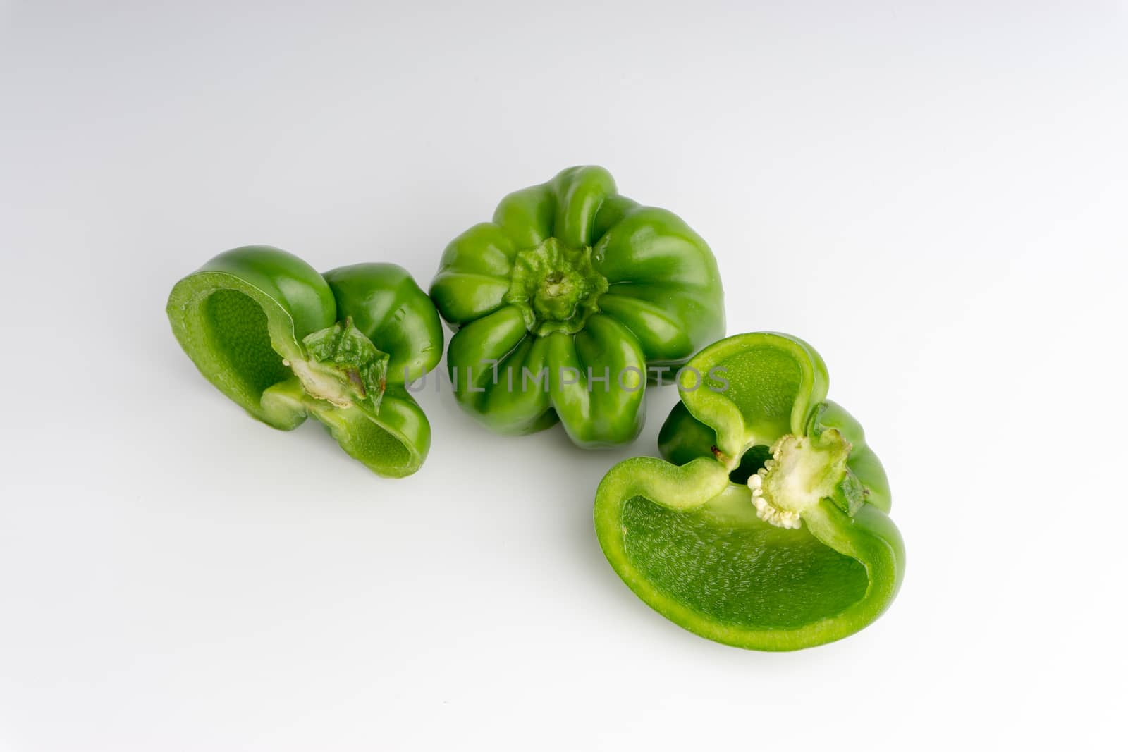 Fresh green bell peppers (capsicum) on a white background by silverwings