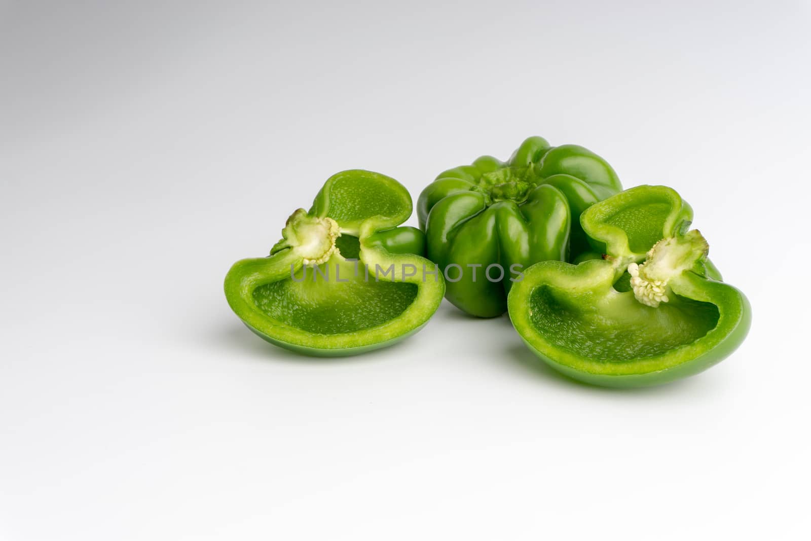 Fresh green bell peppers (capsicum) on a white background by silverwings