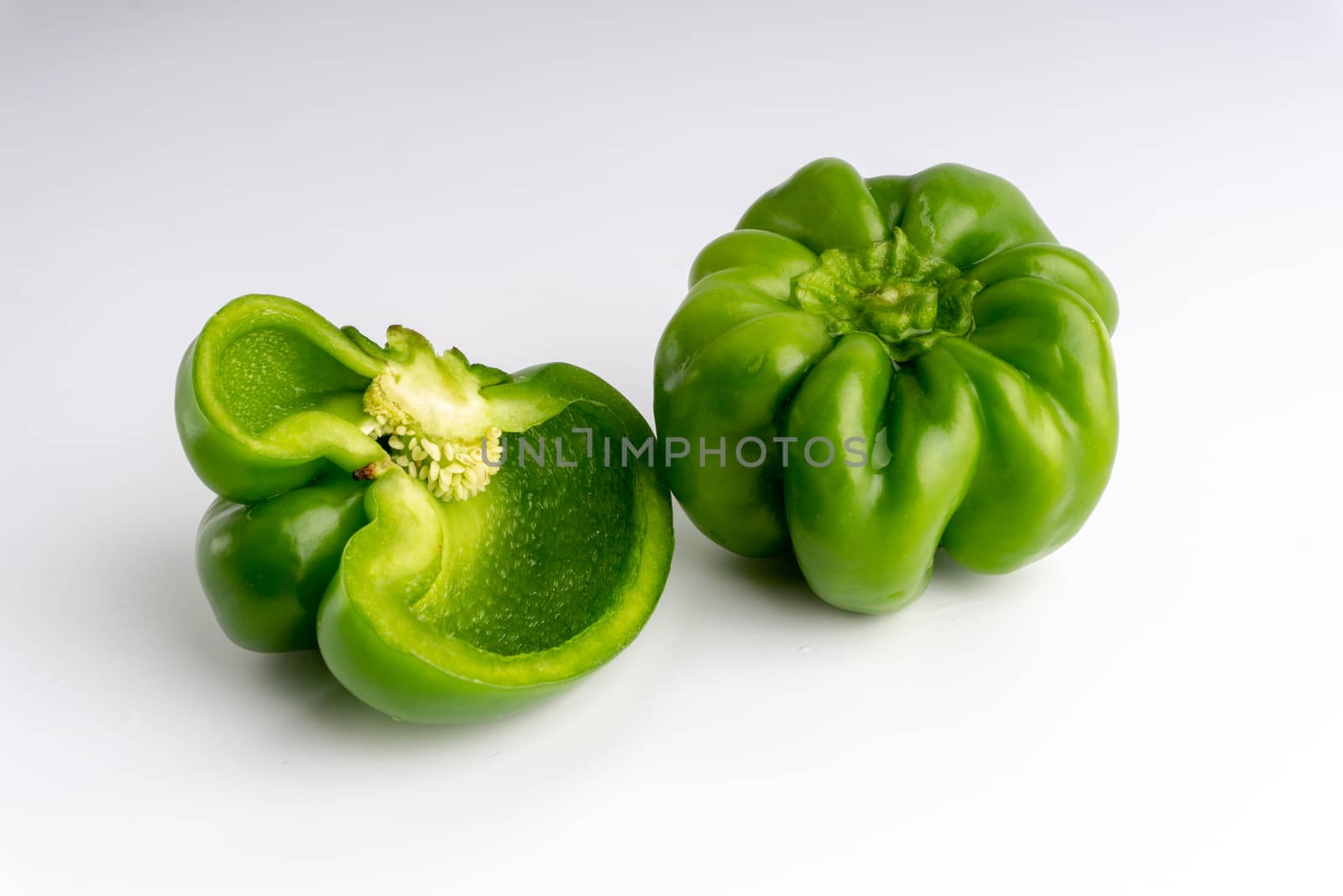 Fresh green bell peppers (capsicum) on a white background by silverwings