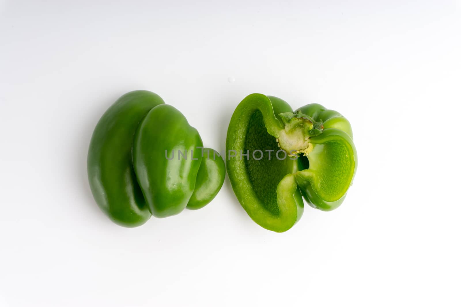 Fresh green bell peppers (capsicum) on a white background by silverwings