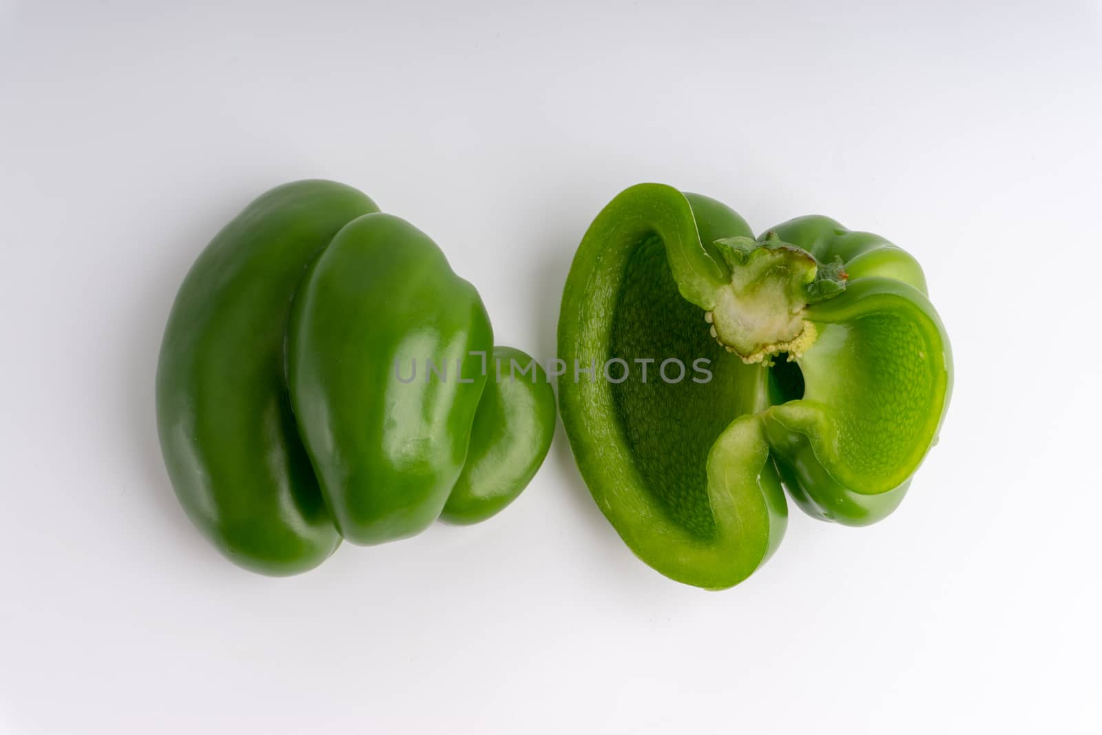 Fresh green bell peppers (capsicum) on a white background by silverwings