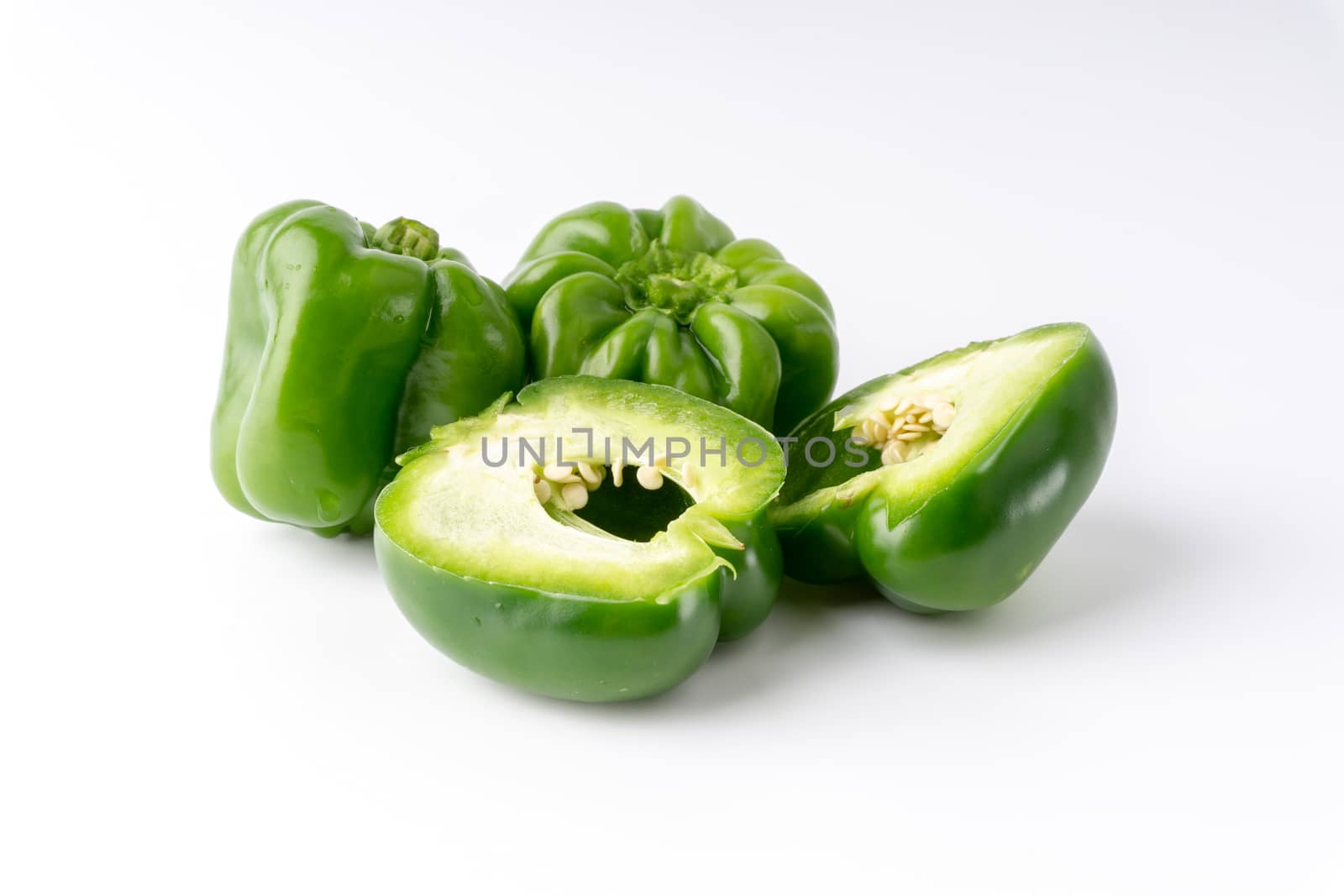 Fresh green bell peppers (capsicum) on a white background by silverwings