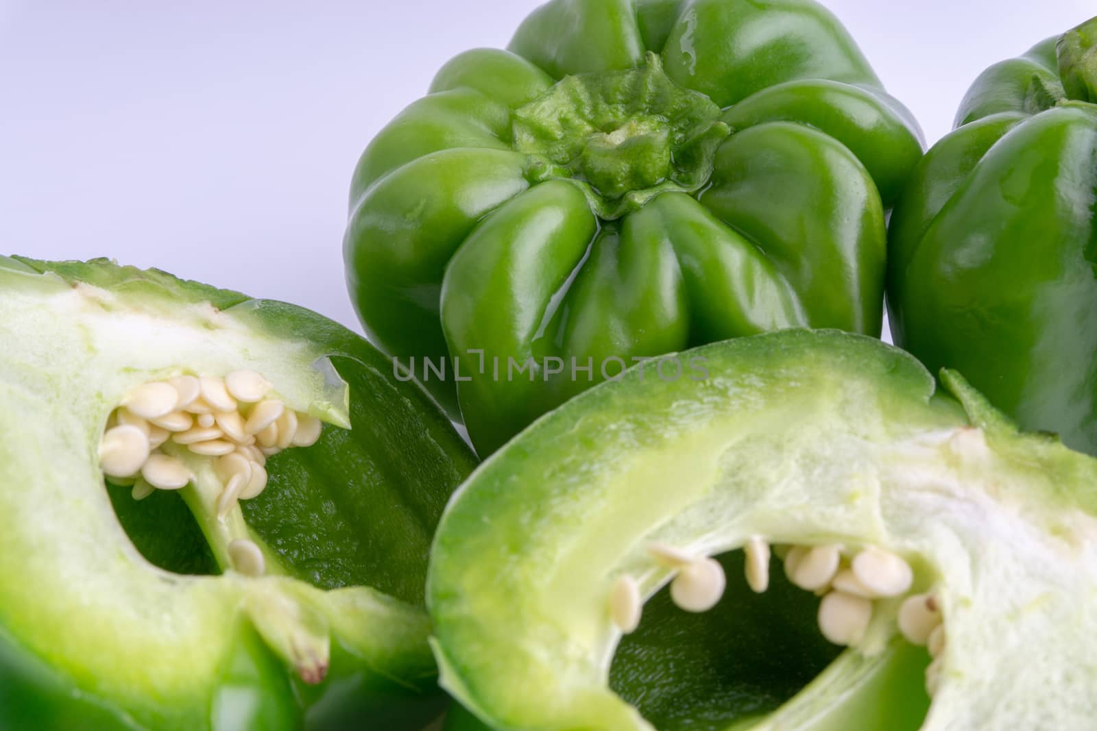 Fresh green bell peppers (capsicum) on a white background by silverwings