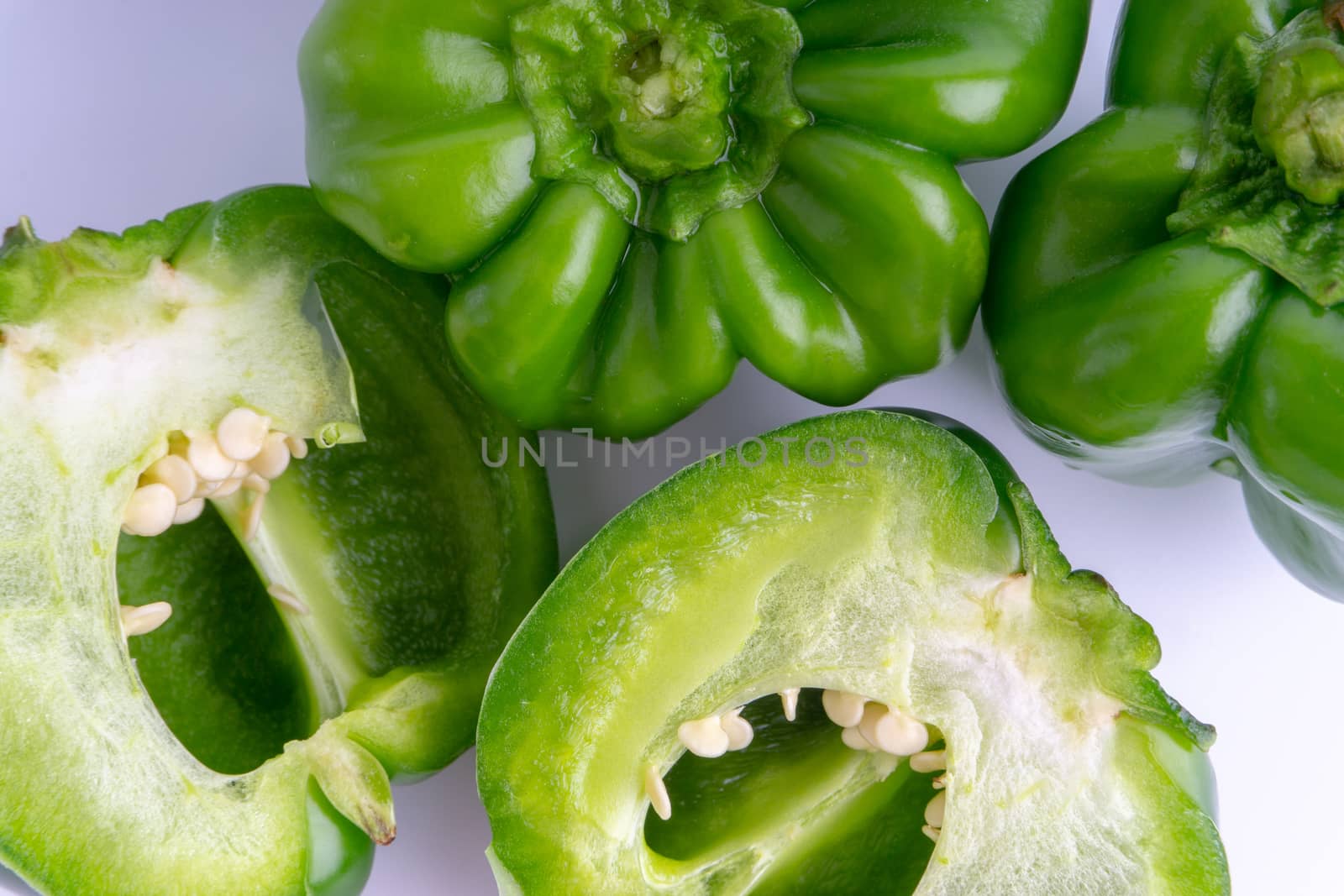 Fresh green bell peppers (capsicum) on a white background by silverwings