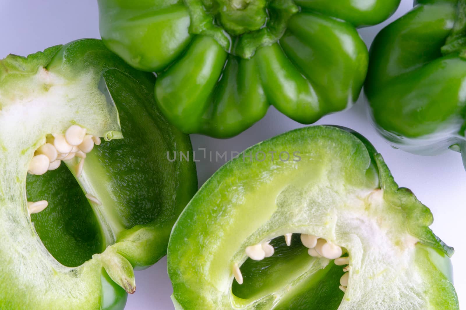 Fresh green bell peppers (capsicum) on a white background by silverwings