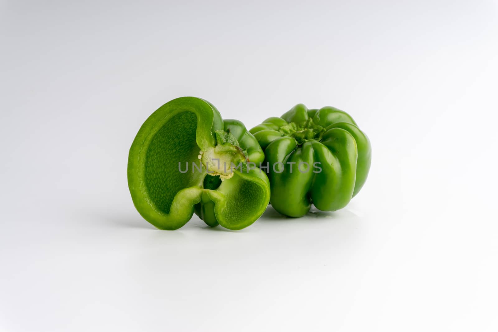 Fresh green bell peppers (capsicum) on a white background by silverwings