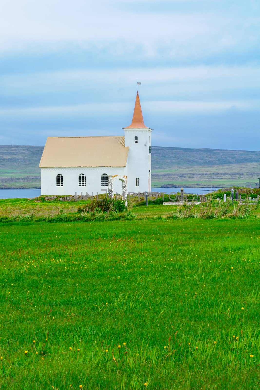 Countryside and a secluded church along the Kollafjordur fjord, in the west fjords region, Iceland