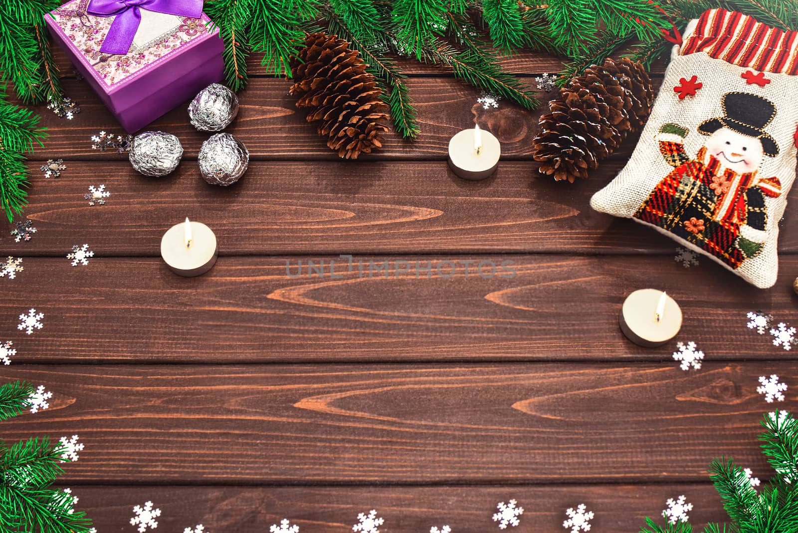 Christmas background Fir branches, cones, Candles, candy and gifts on a wooden background . Space for text. View from above. Christmas atmosphere