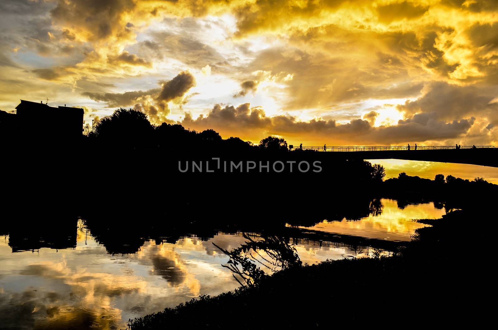 Beautiful yellow Sunset with clouds on the Arno River in Florence, Italy