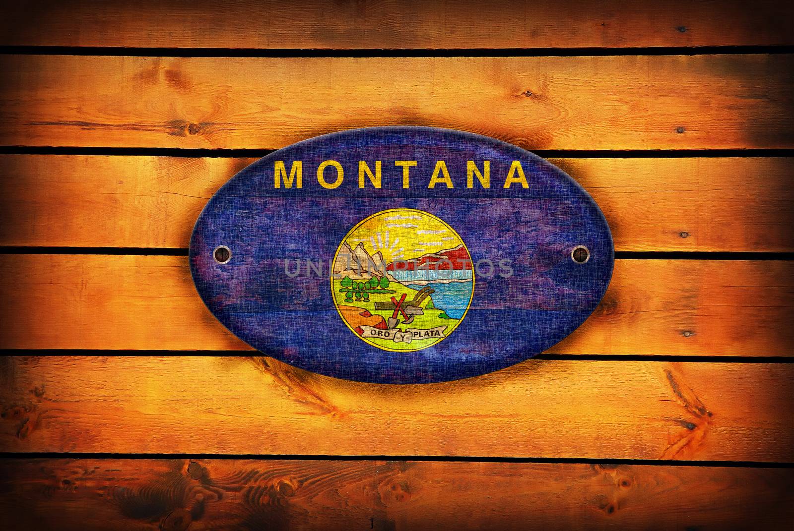 A Montana flag on brown wooden planks.