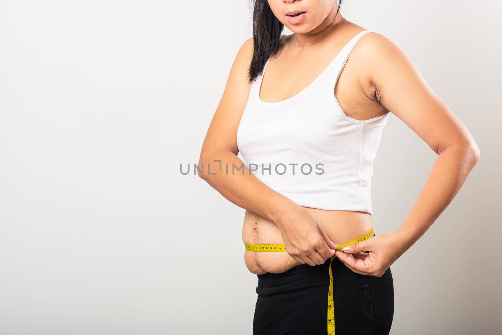 Asian mother woman use section postpartum scar measuring waist stretch mark loose lower abdomen skin she fat after pregnancy baby birth isolated on white background, Healthy belly excess body concept