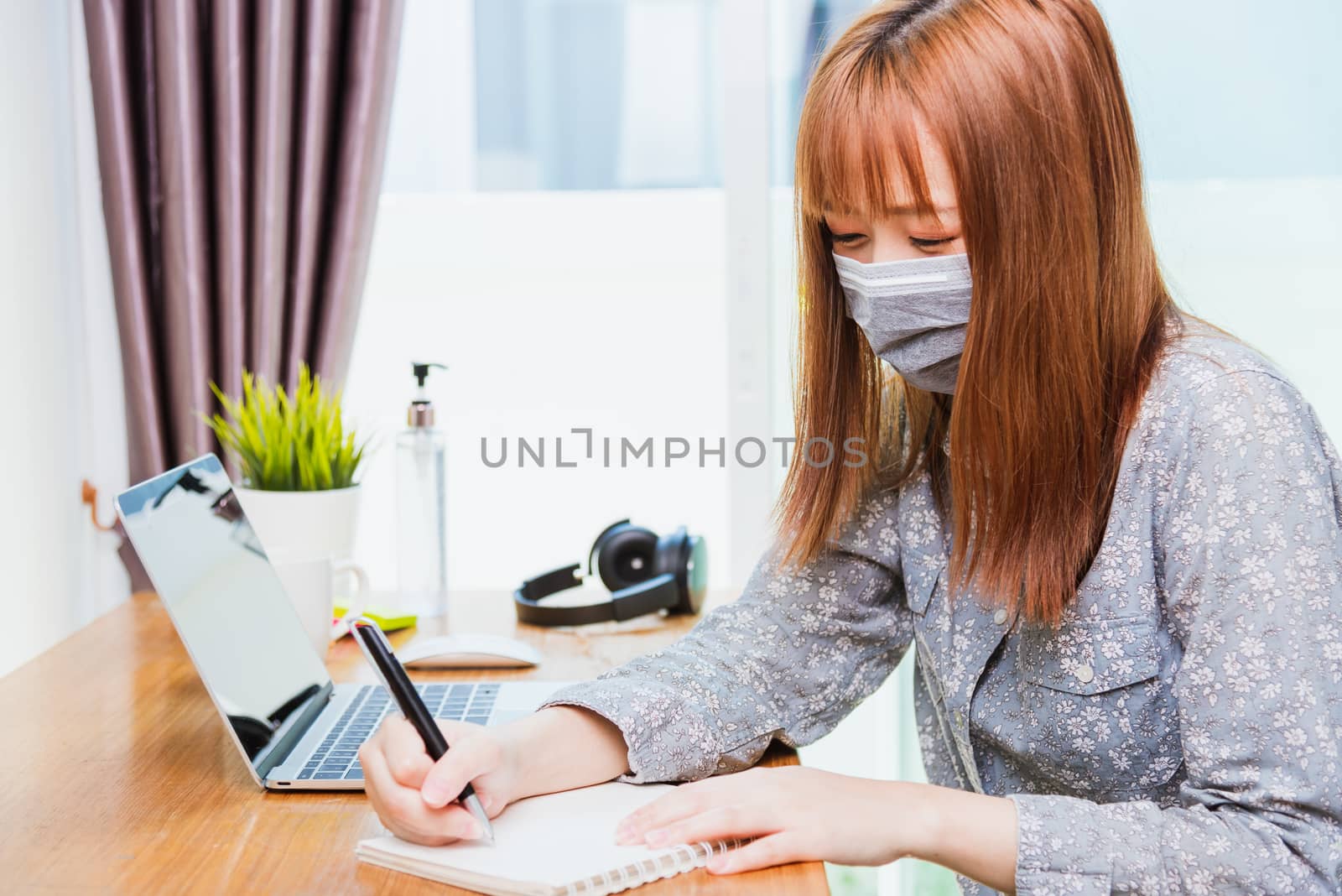 business woman wearing face mask protective write note booklist  by Sorapop