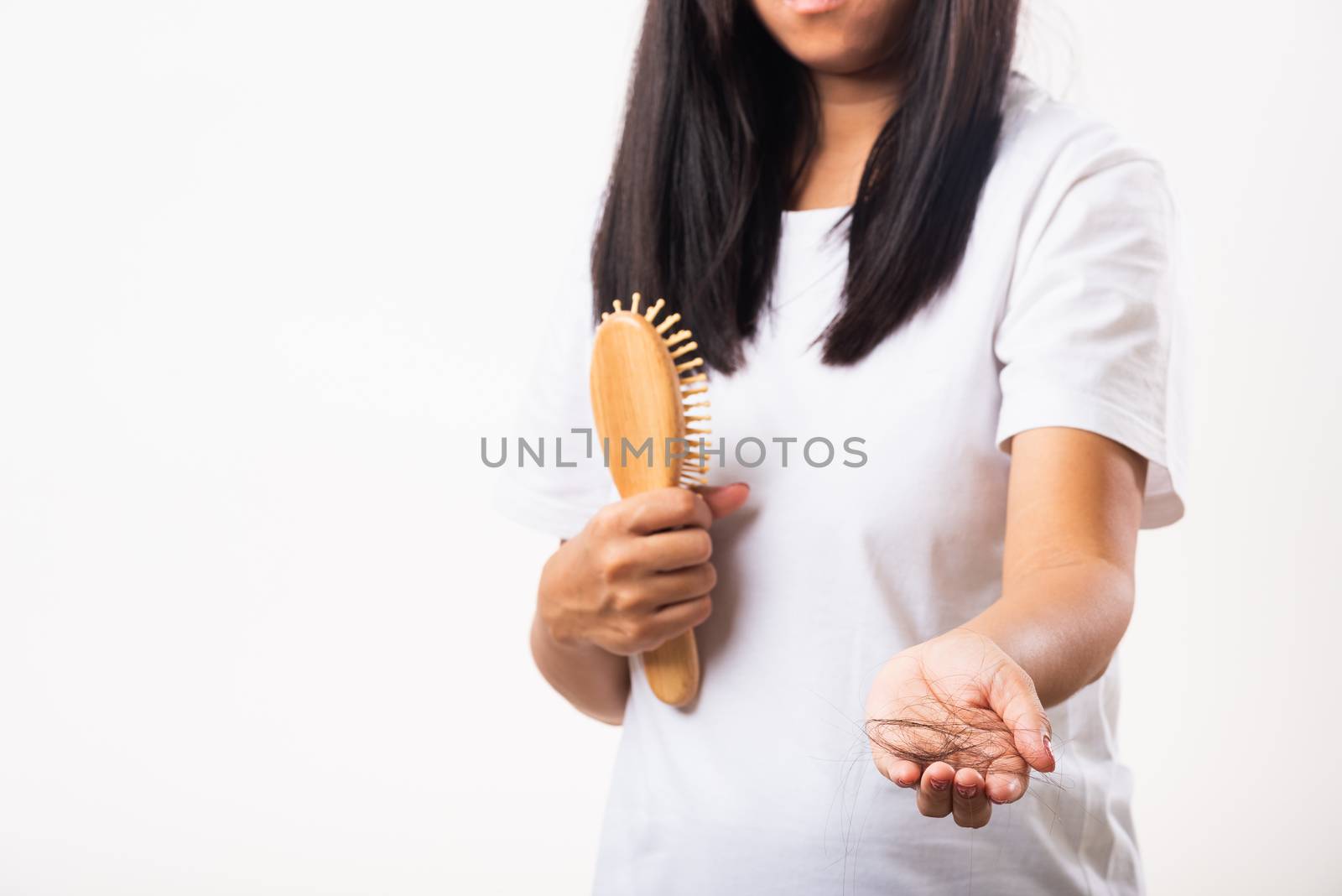 Asian woman unhappy weak hair problem her hold a hairbrush and she showing damaged long loss hair from the brush on hand, isolated on white background, Medicine health care concept