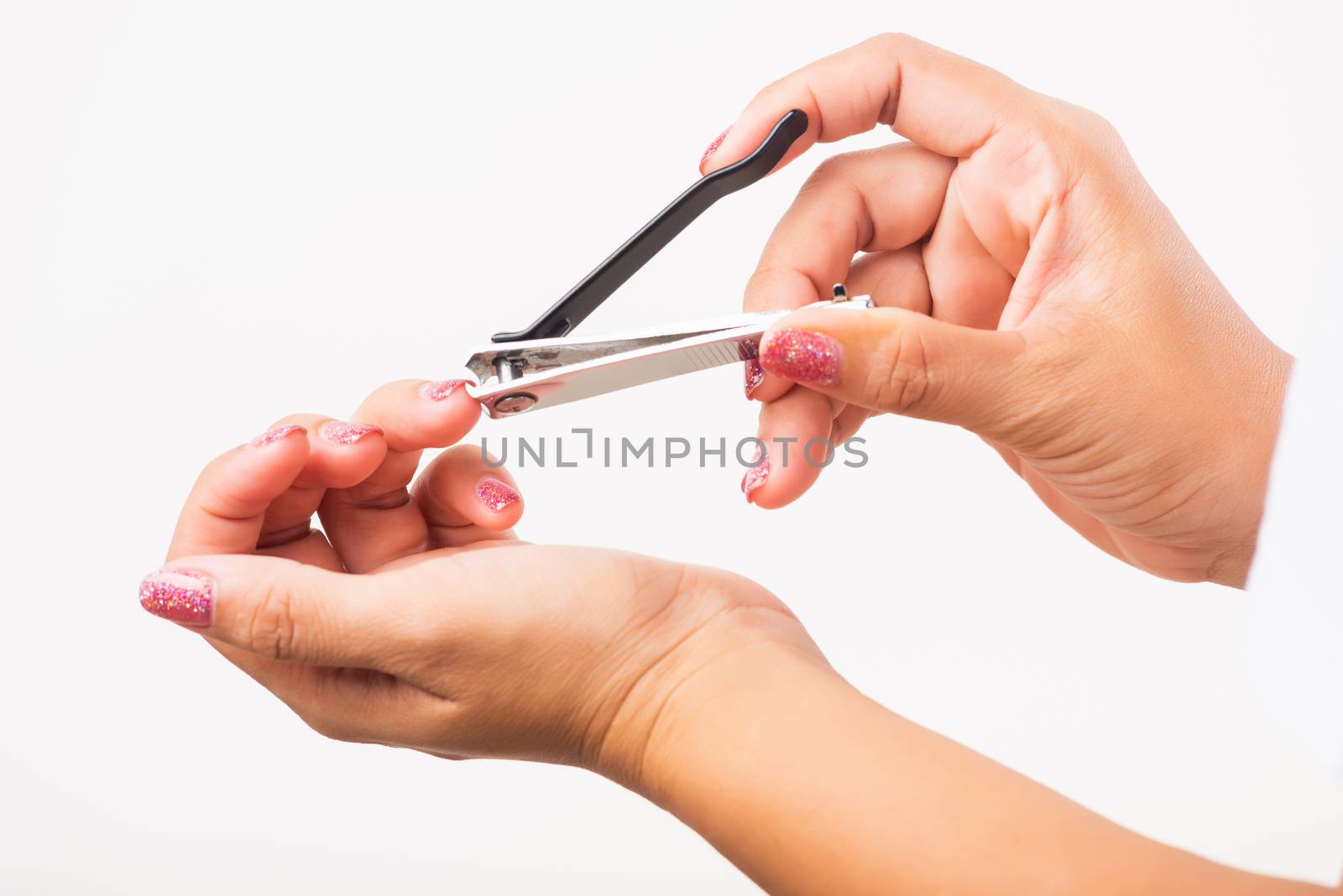 Woman cutting nails on finger using a nail clipper by Sorapop