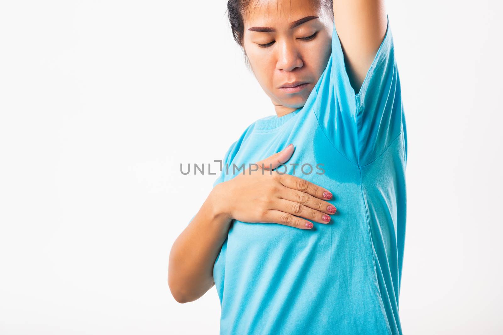 Closeup young Asian young woman hyperhidrosis sweating. Female very badly have armpit sweat stain on her clothes, studio shot isolated on white background, Healthcare medical concept