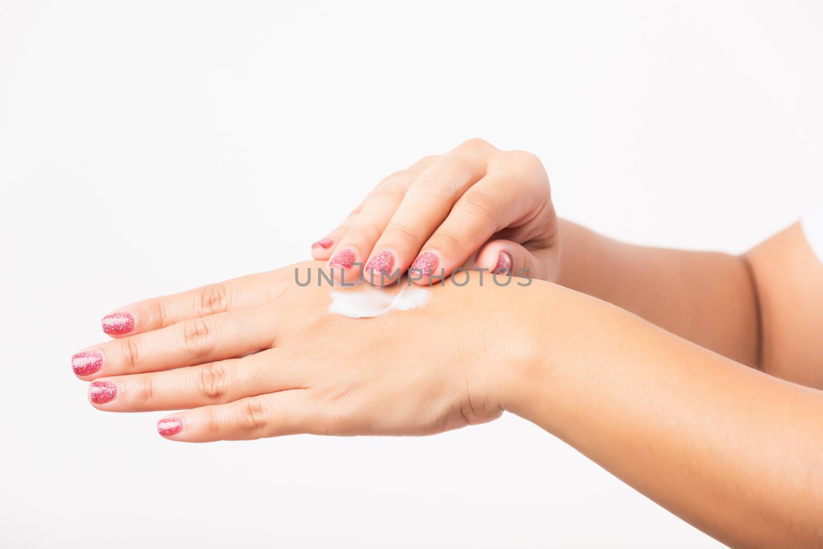 Closeup young Asian woman applying lotion cosmetic moisturizer cream on her behind the palm skin hand, studio shot isolated on white background, Healthcare medical and hygiene skin body care concept