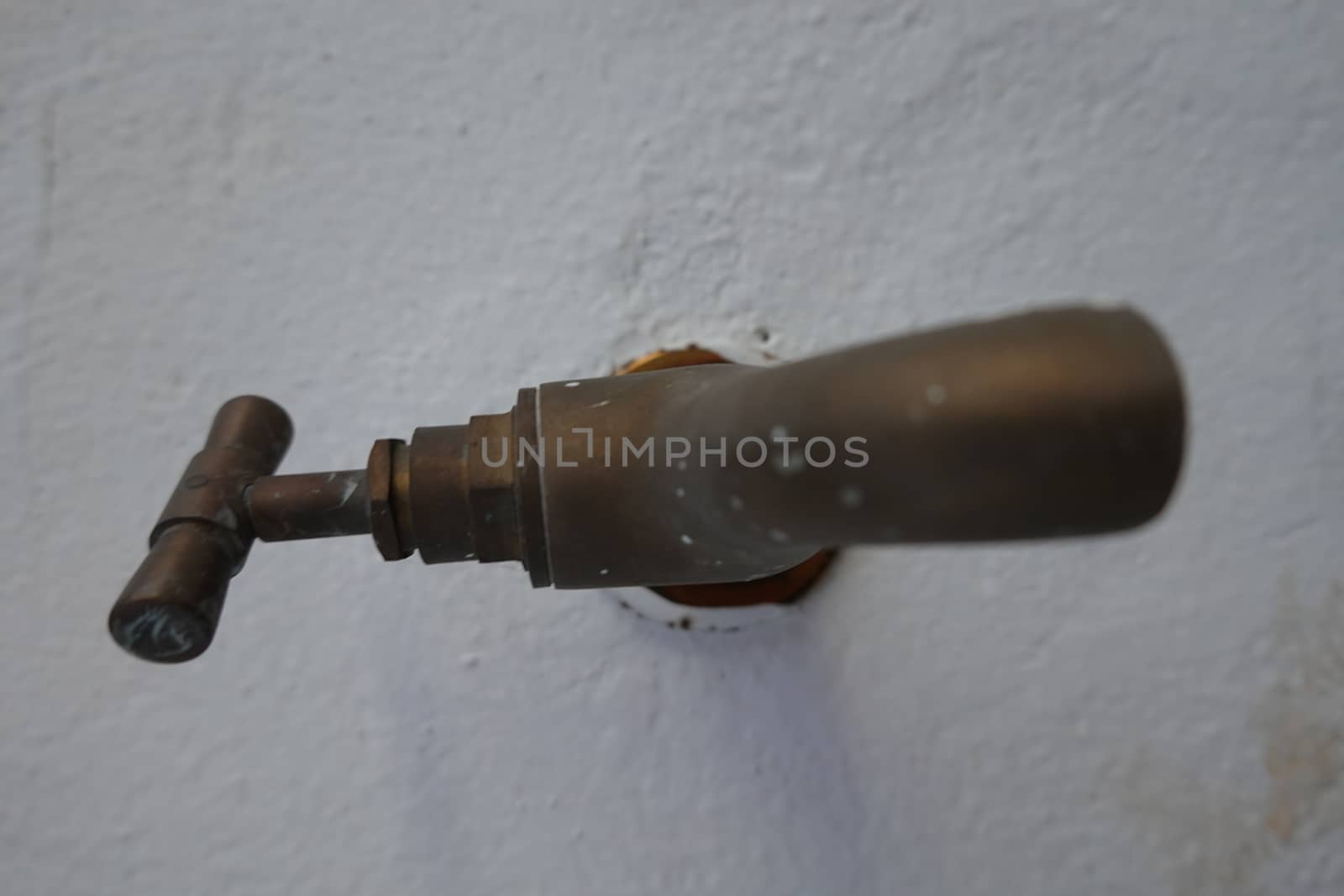 an old rustic faucet with a white background.