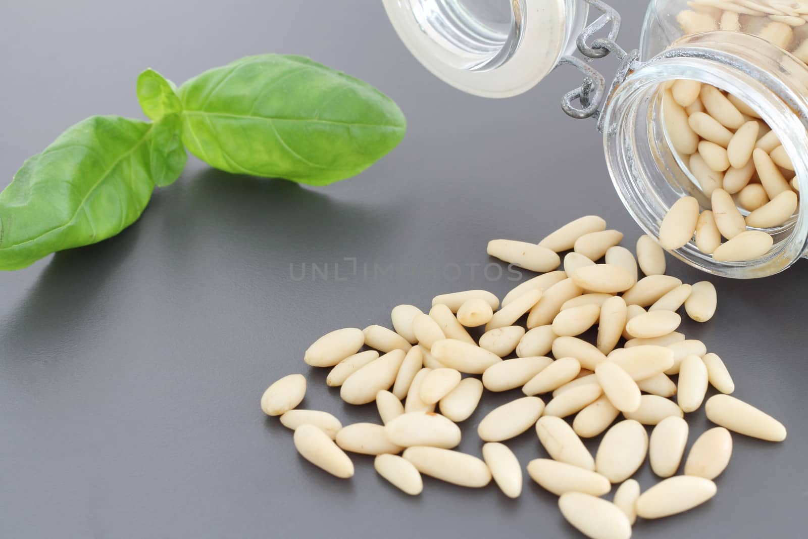 Pine nuts in glass jar and basil