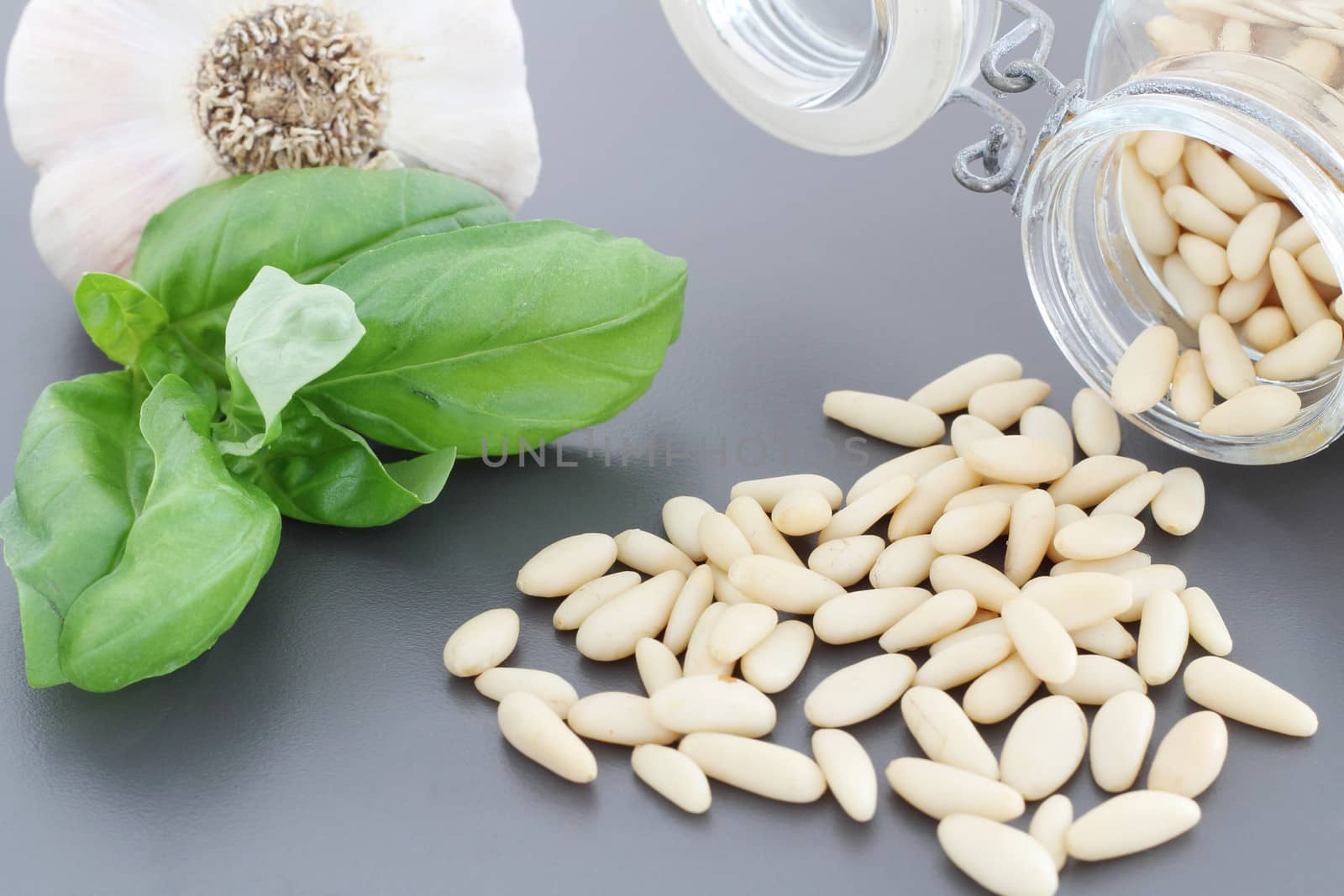 Pine nuts in glass jar and basil