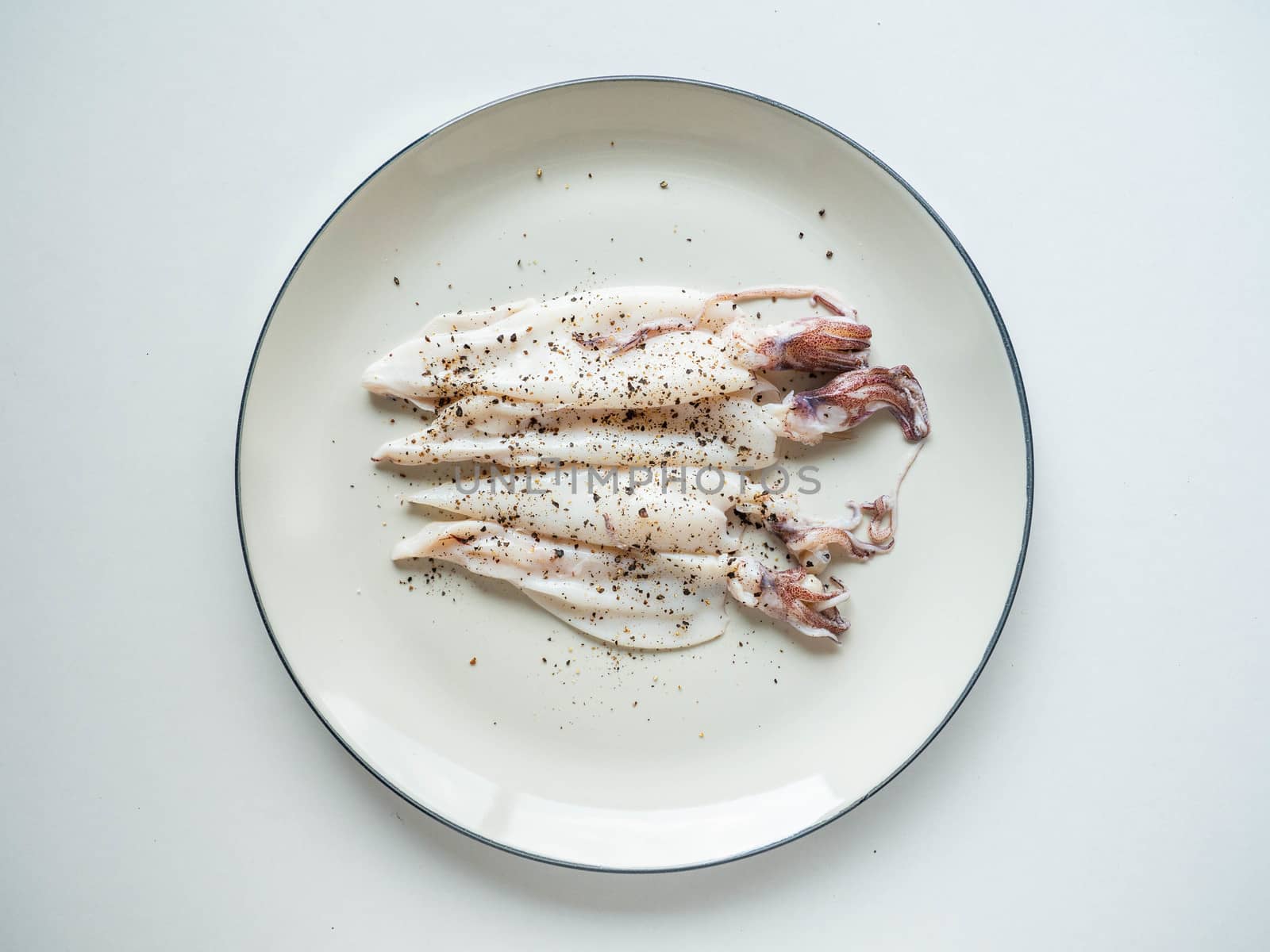 Fresh squid Topping
black pepper from the market on dish White and White background