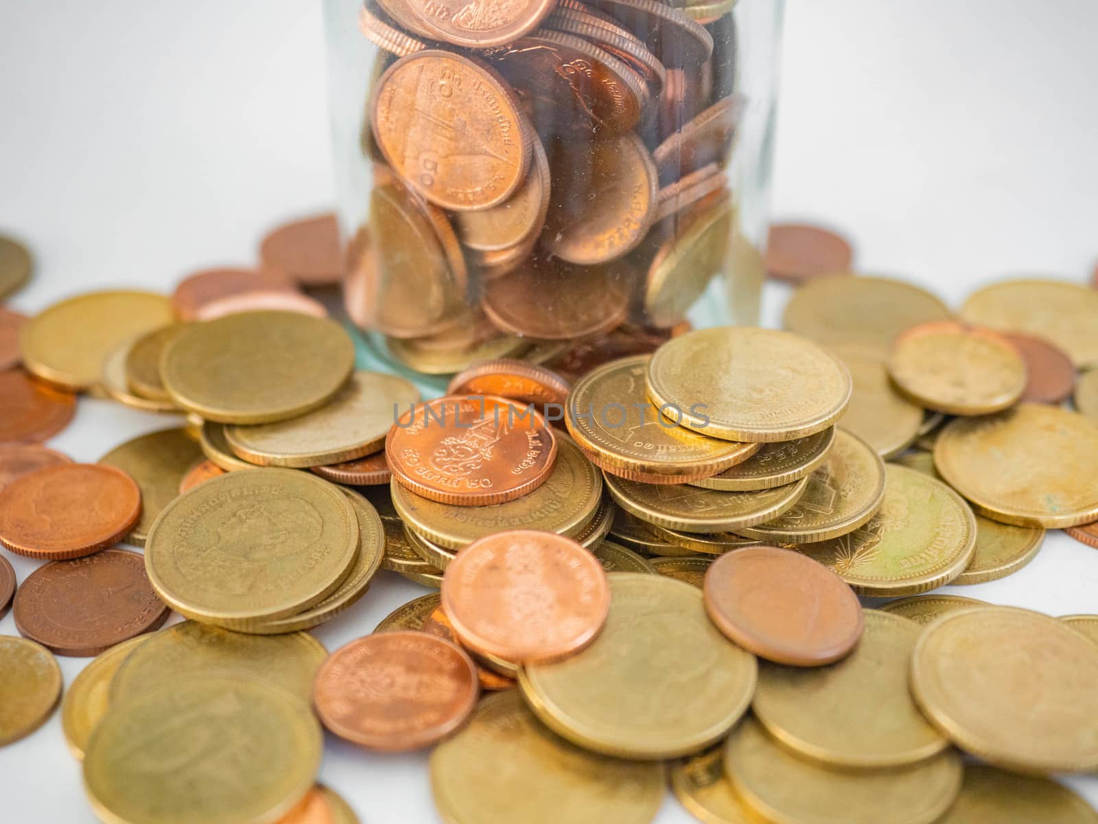 Thai Baht Coins colors Gold set in the mountains,Is the currency of Thailand.For business expenses,Coin is in a jar of money saving,White background