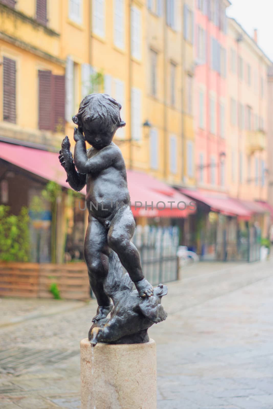 Statue and street scene in the historic center of Modena, Emilia-Romagna, Italy