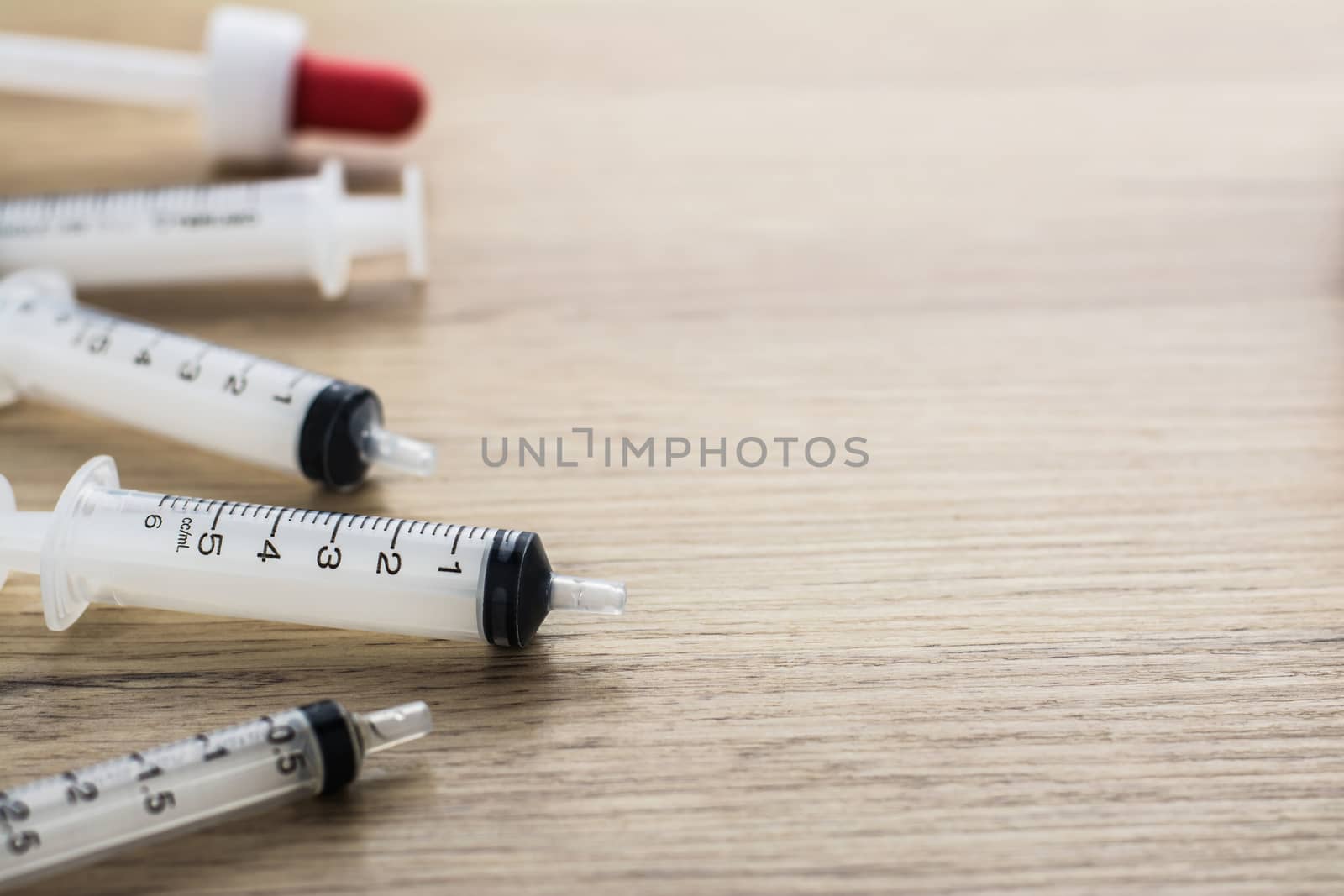 Empty syringes barrel on the wooden table with copy space.
