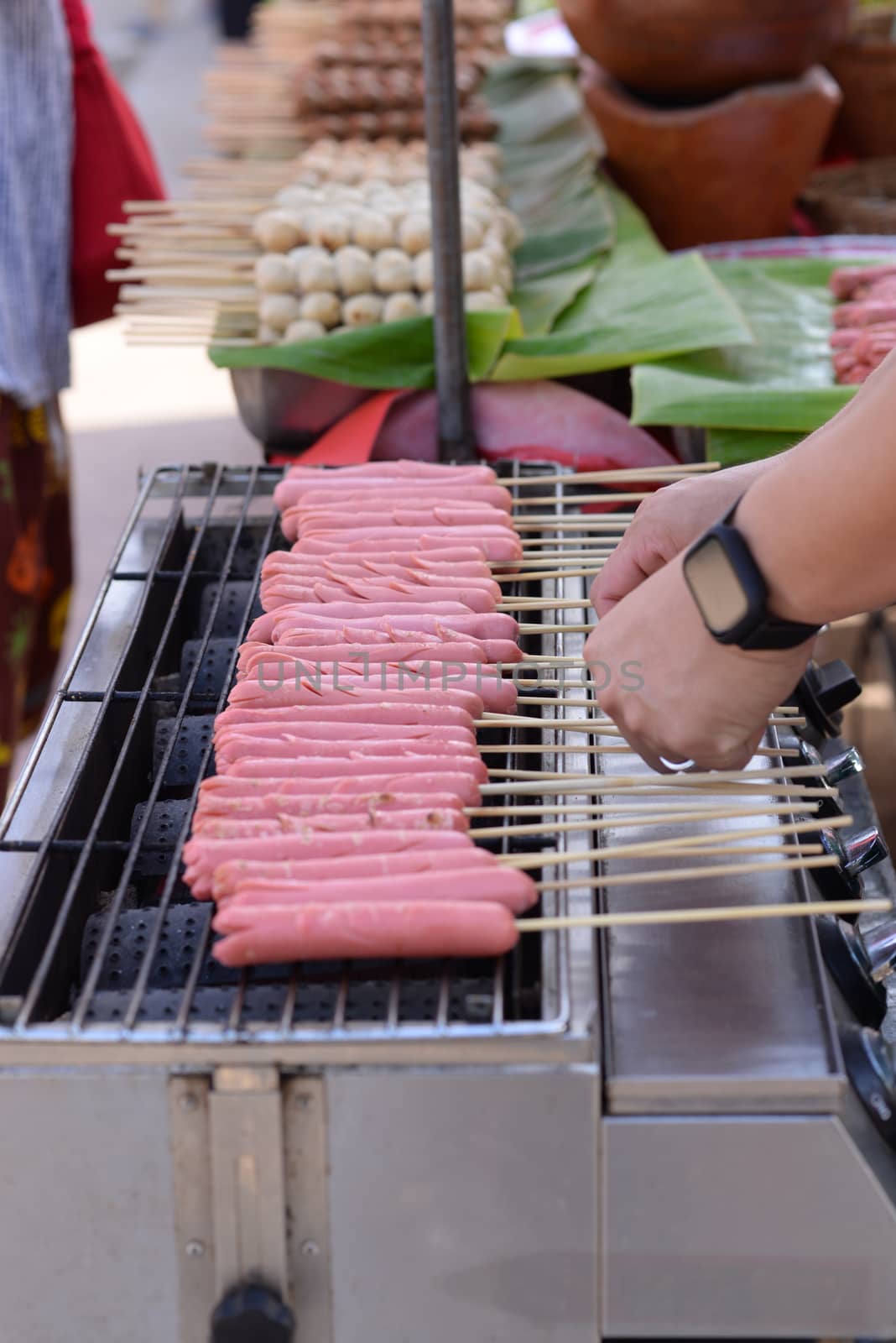 Pink hotdog Skewers Is being roasted on an electric stove