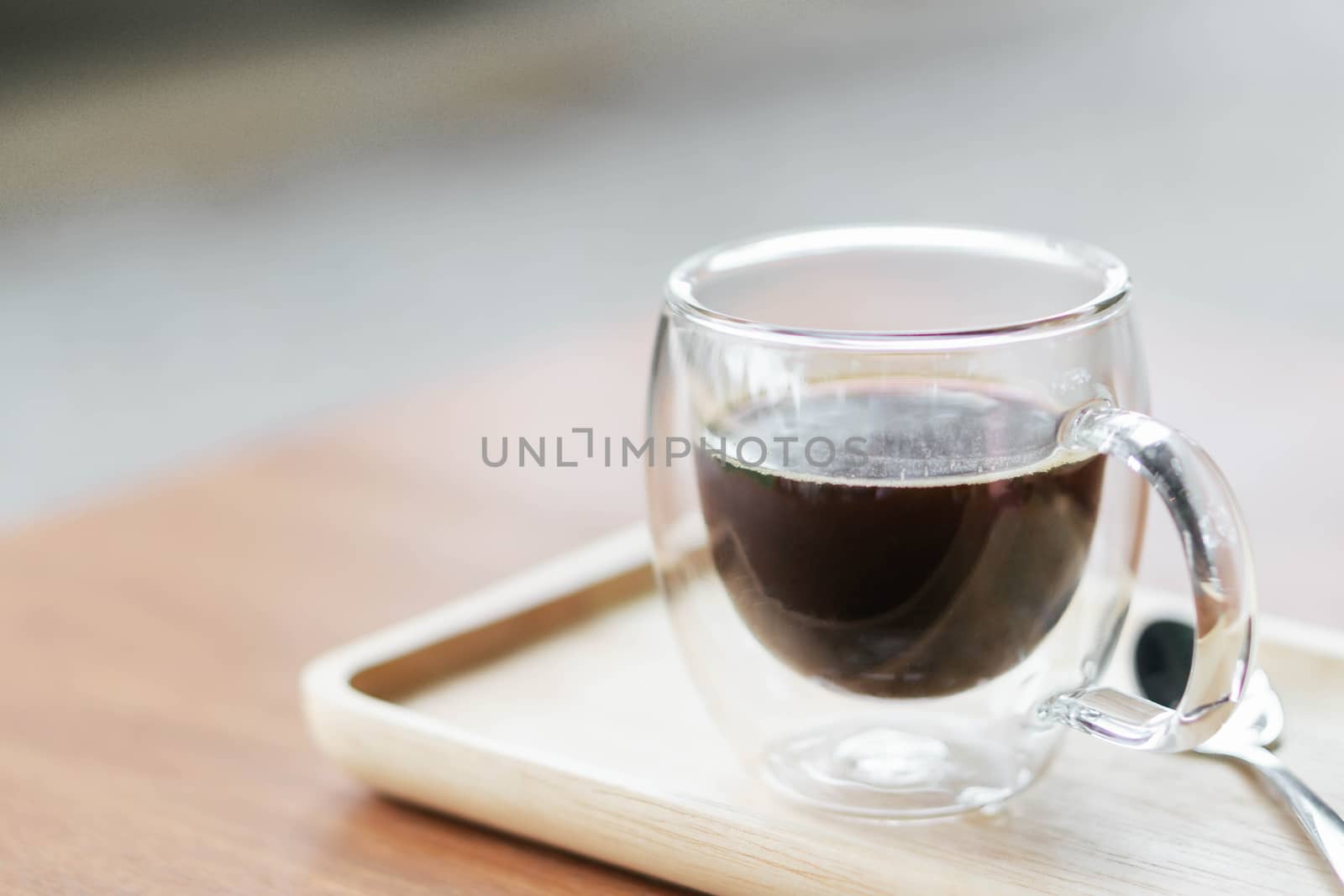 Closeup glass of hot americano coffee on wood table, selective f by pt.pongsak@gmail.com
