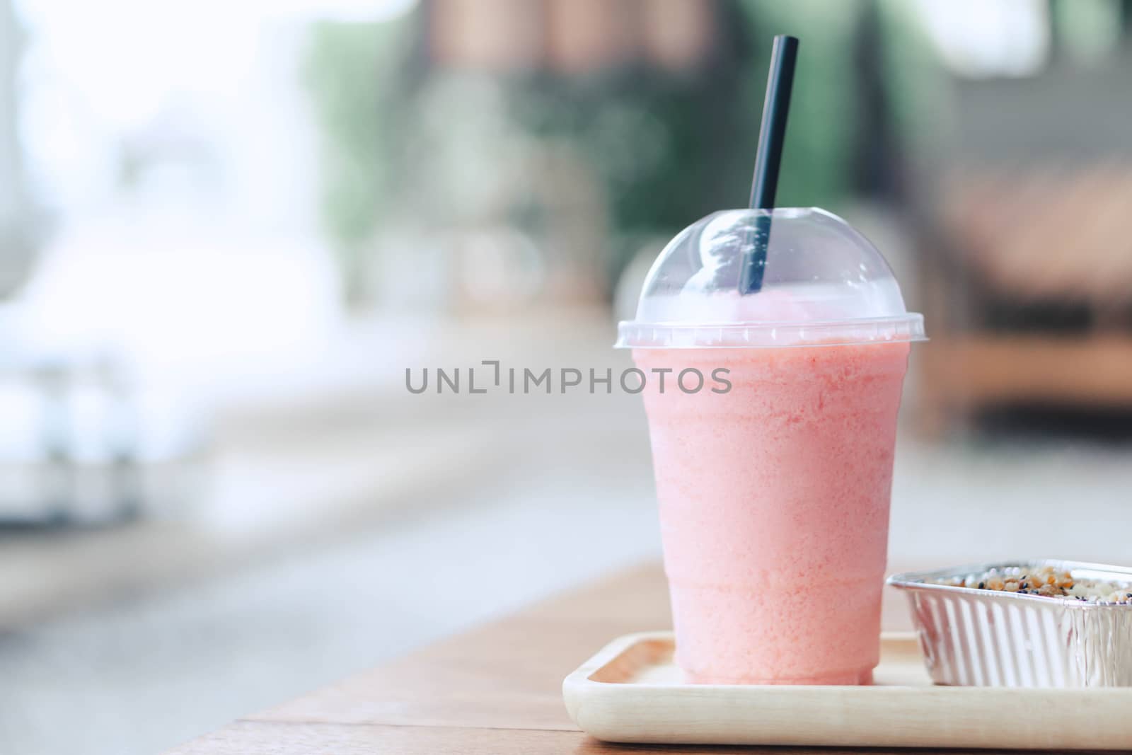 Closeup  strawberry smoothie and cake with green nature background, selective focus