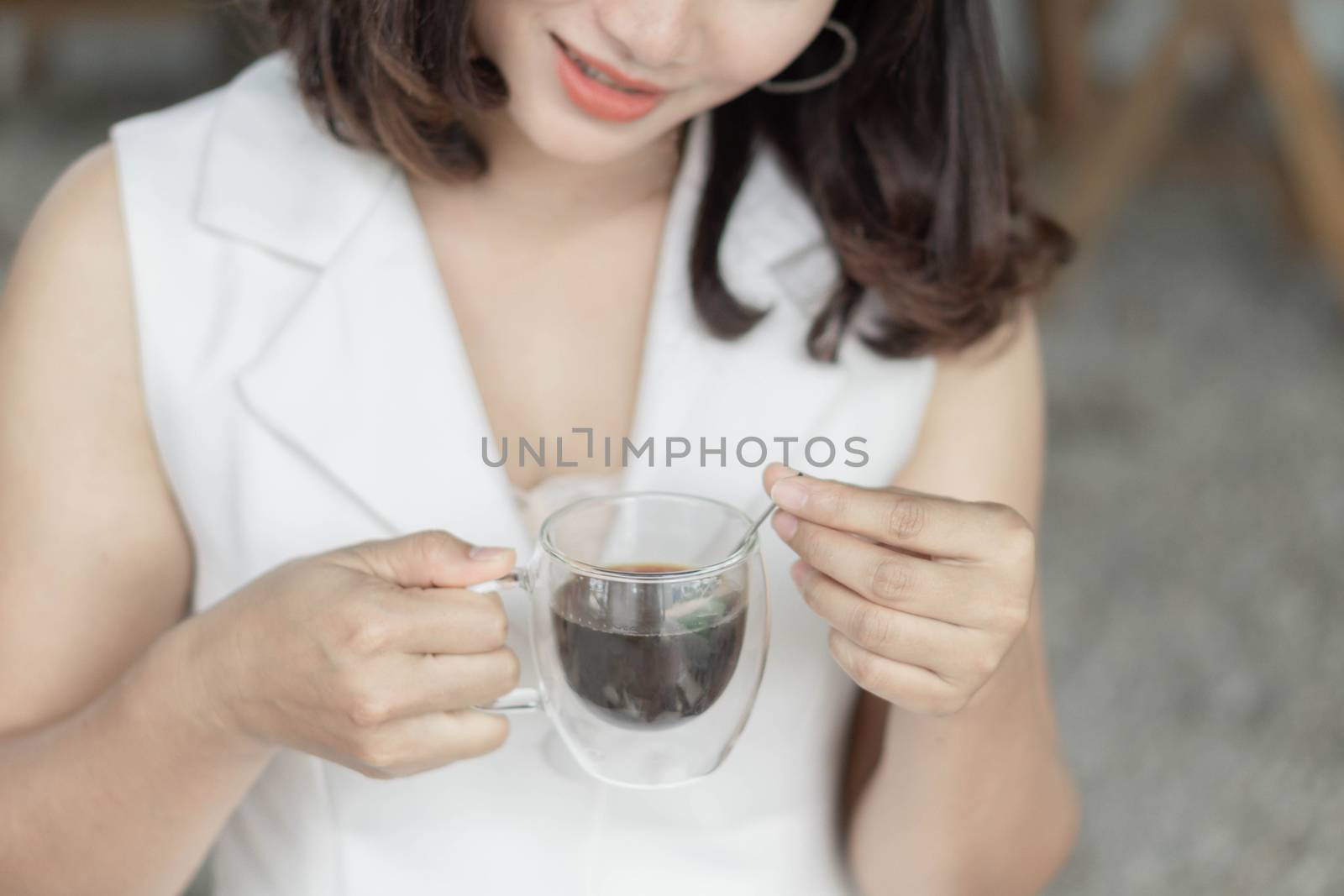 Close up woman drinking hot americano coffee from glass with lig by pt.pongsak@gmail.com