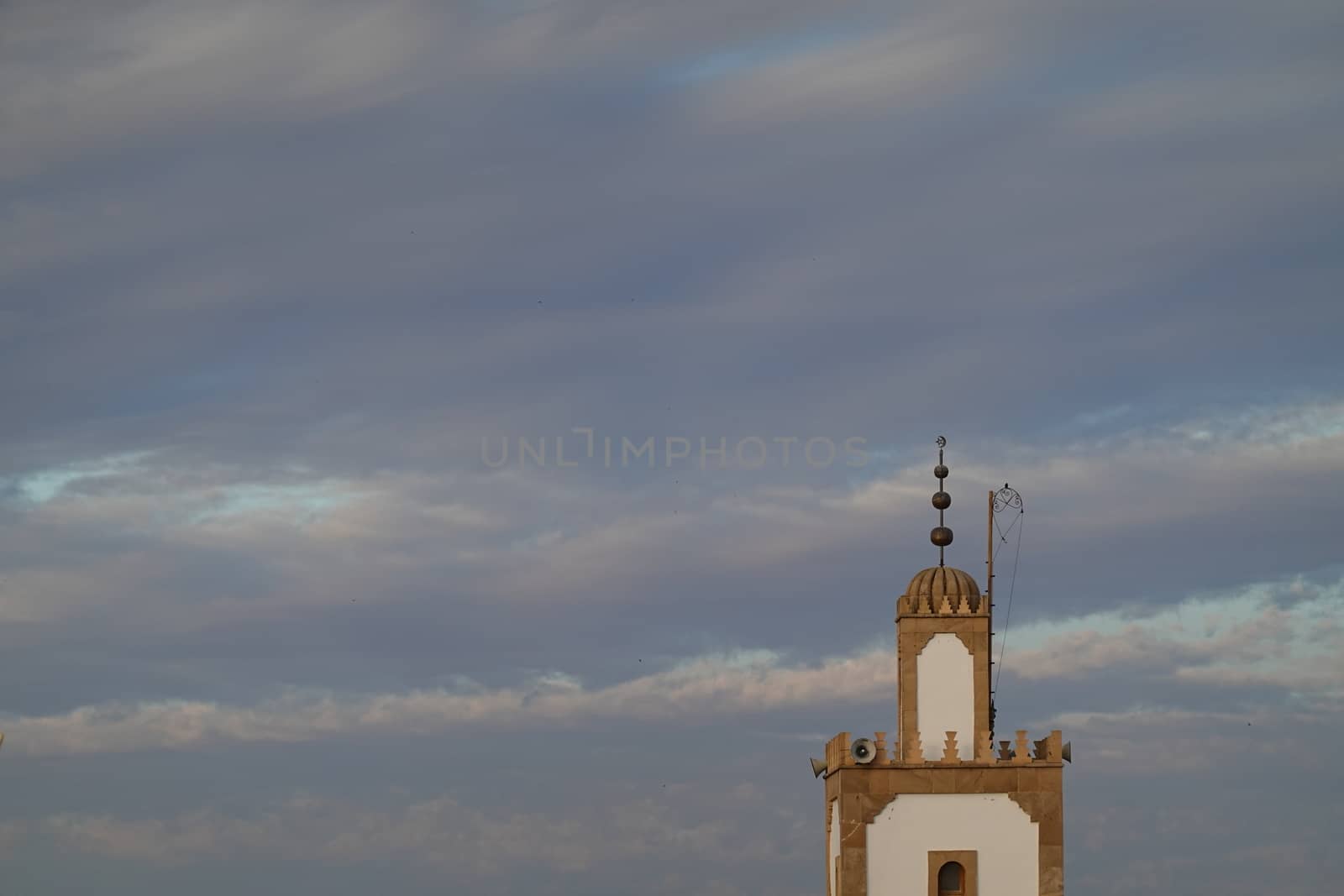 a mosk tower in a blue sky full of beautiful clouds.