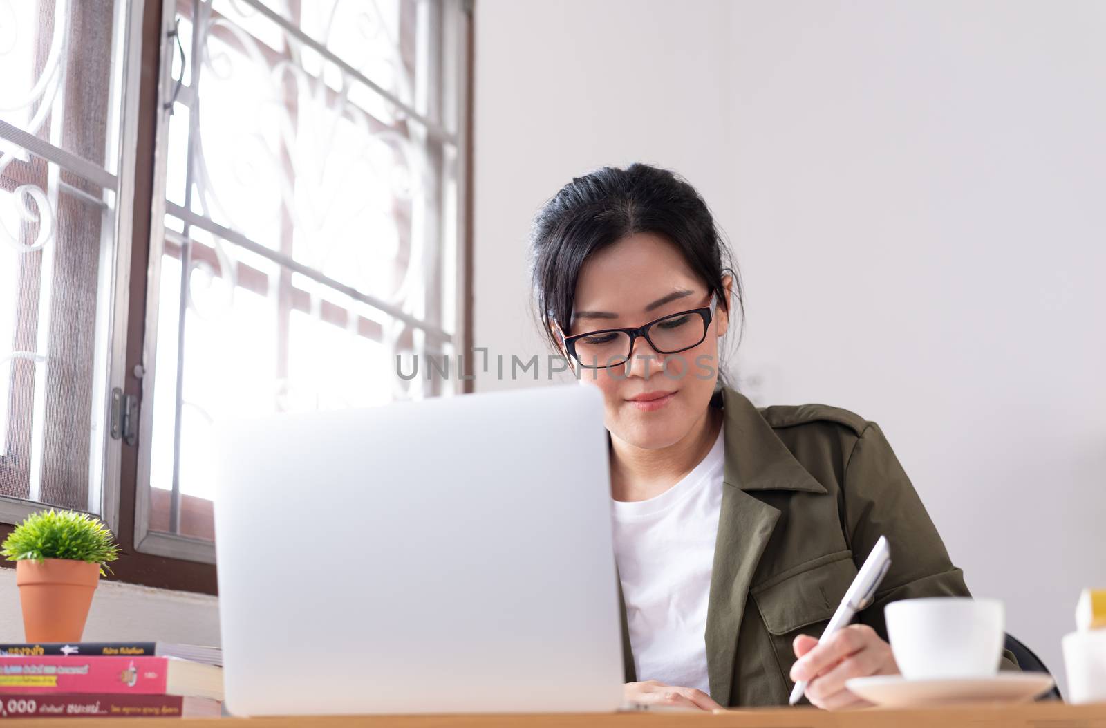 Modern young Asian woman working from home.