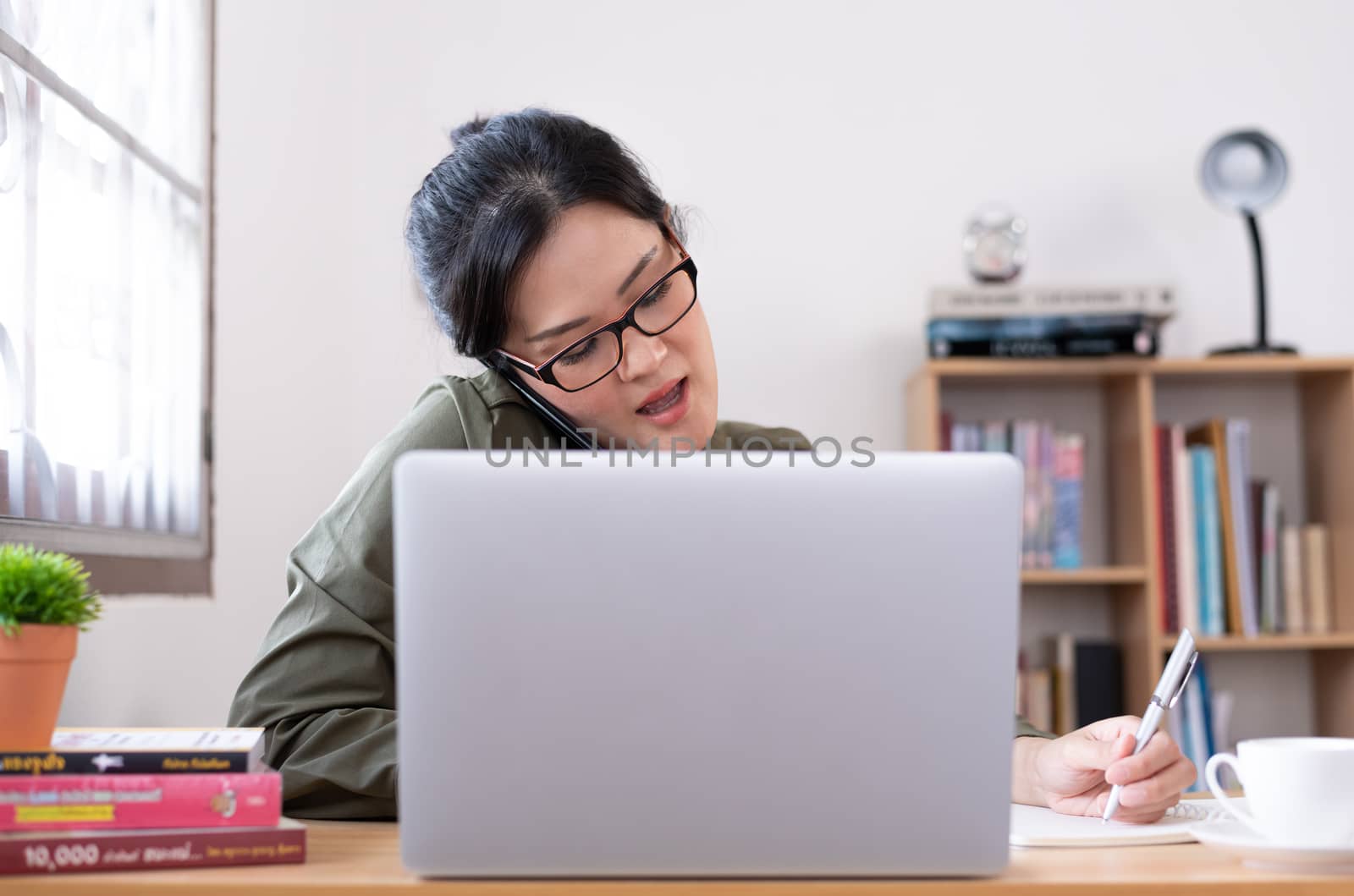 Modern young Asian woman working from home.