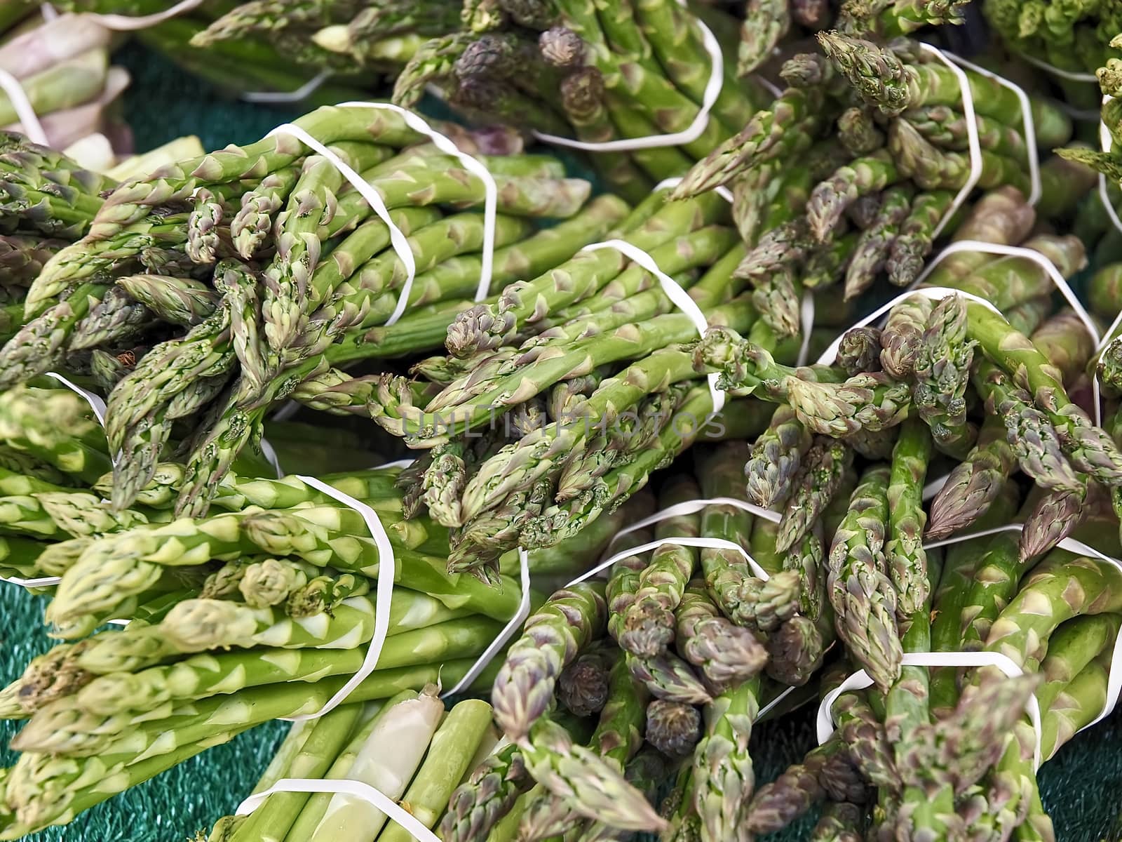 Macro of green asparagus bunches at a food market