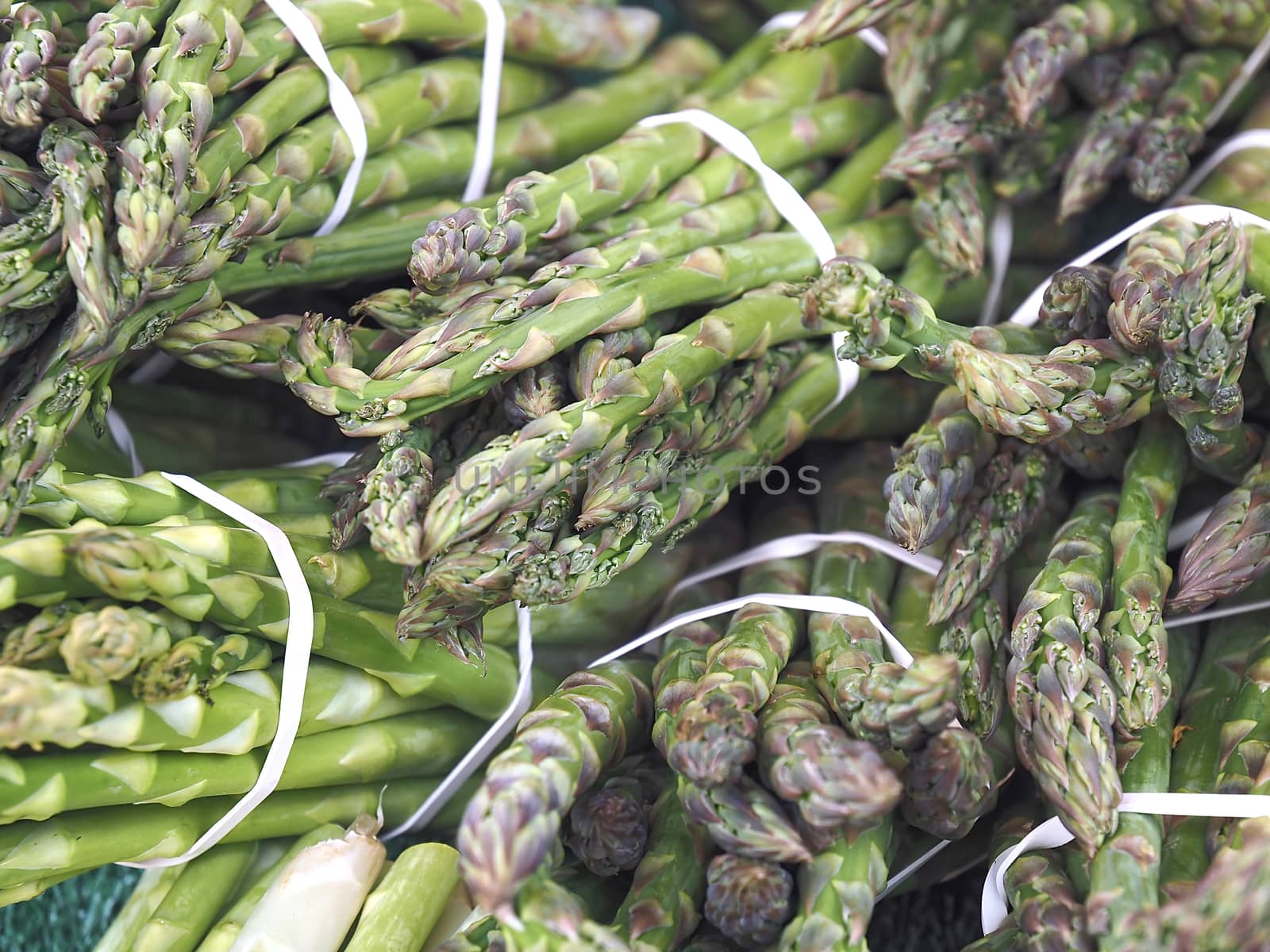 Closeup of bunches of green asparagus at a food market by Stimmungsbilder