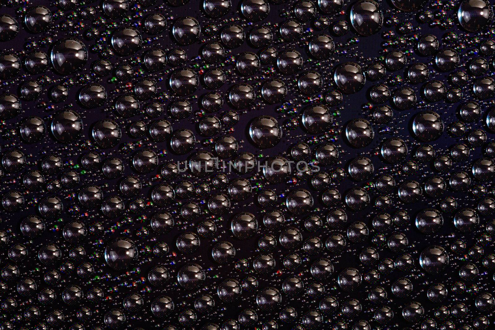 water drops on surface of screen of modern phone, close-up with selective focus and blur.