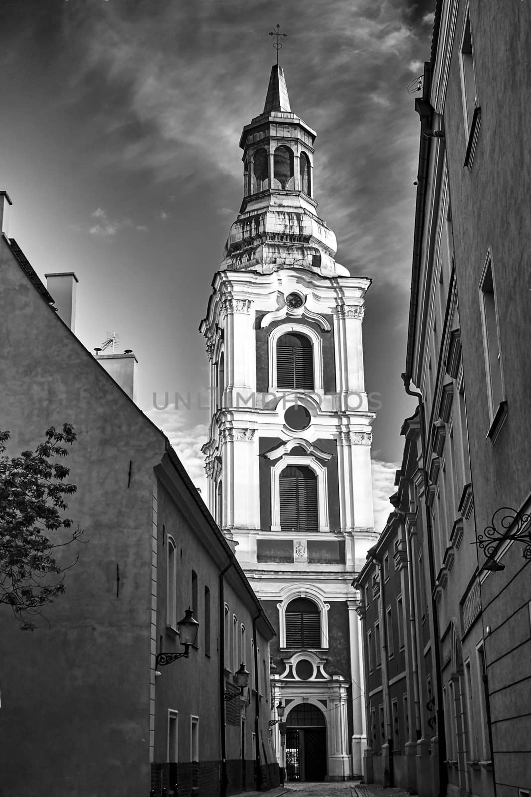 narrow street and belfry of the baroque church in Poznan, black and white