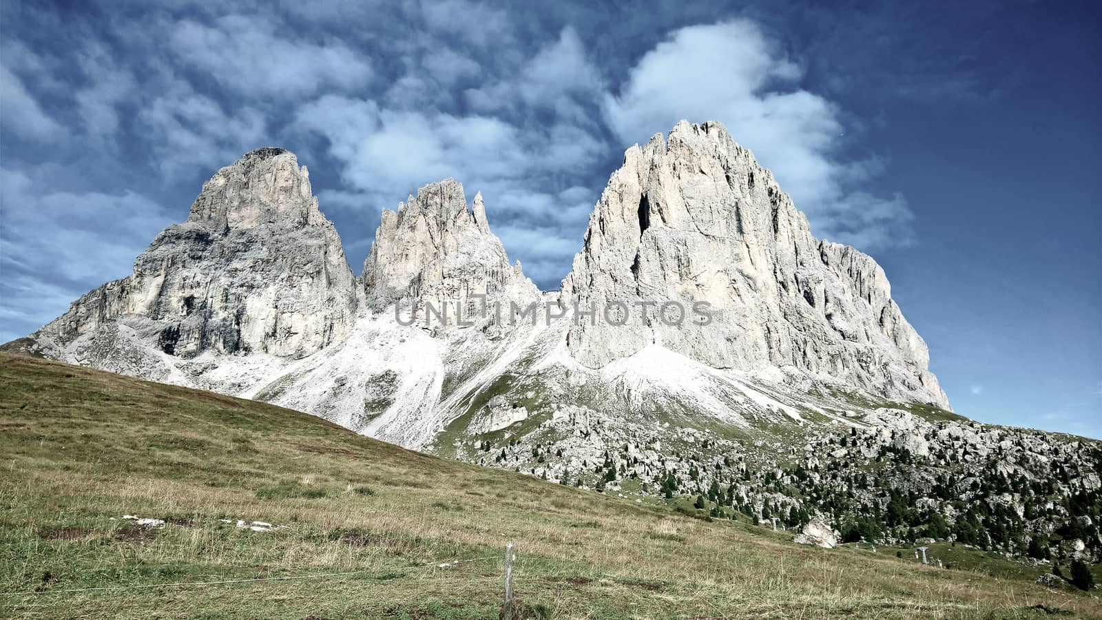 Trentino Alto - Adige, Italy - 06/15/2020: cenic alpine place with magical Dolomites mountains in background, amazing clouds and blue sky in Trentino Alto Adige region, Italy, Europe