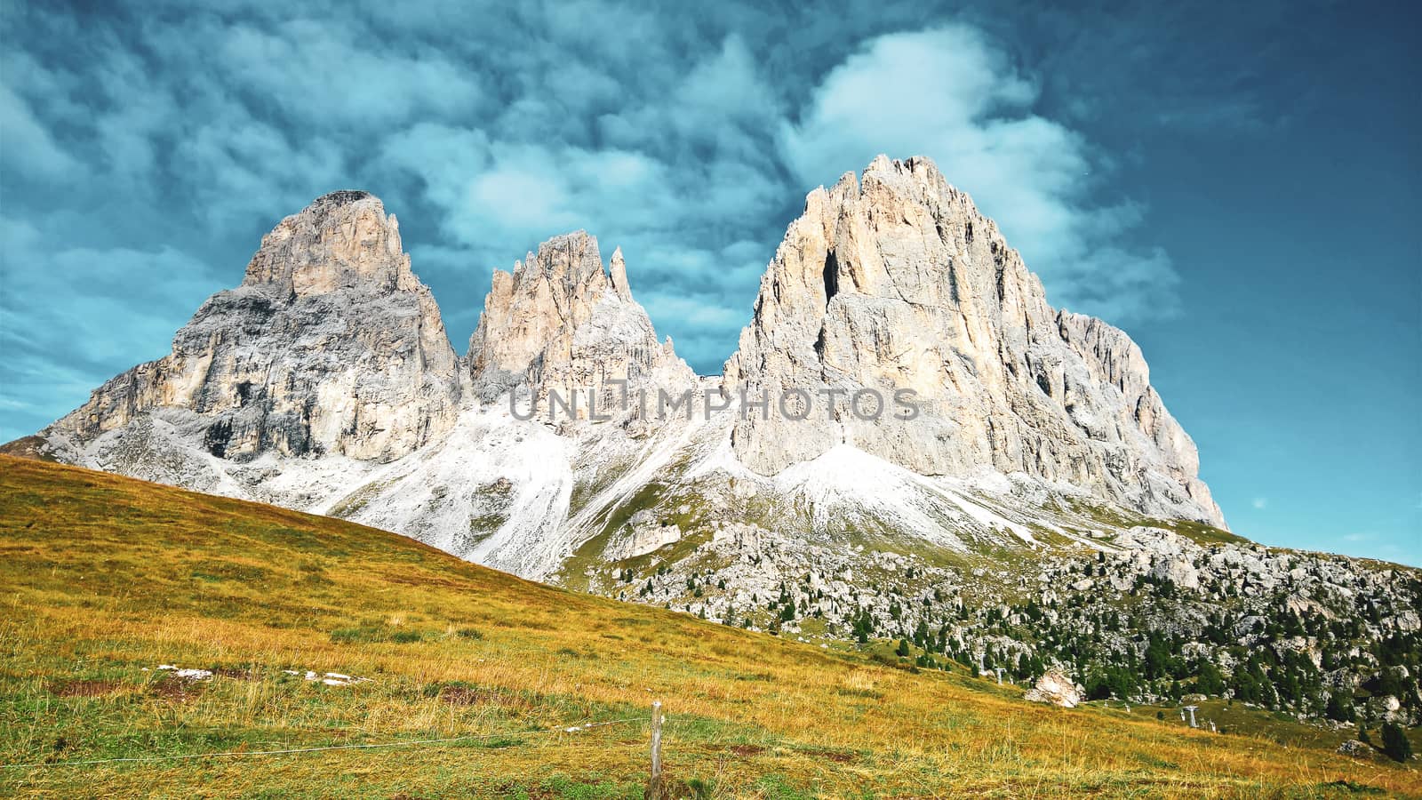 Trentino Alto - Adige, Italy - 06/15/2020: cenic alpine place with magical Dolomites mountains in background, amazing clouds and blue sky in Trentino Alto Adige region, Italy, Europe