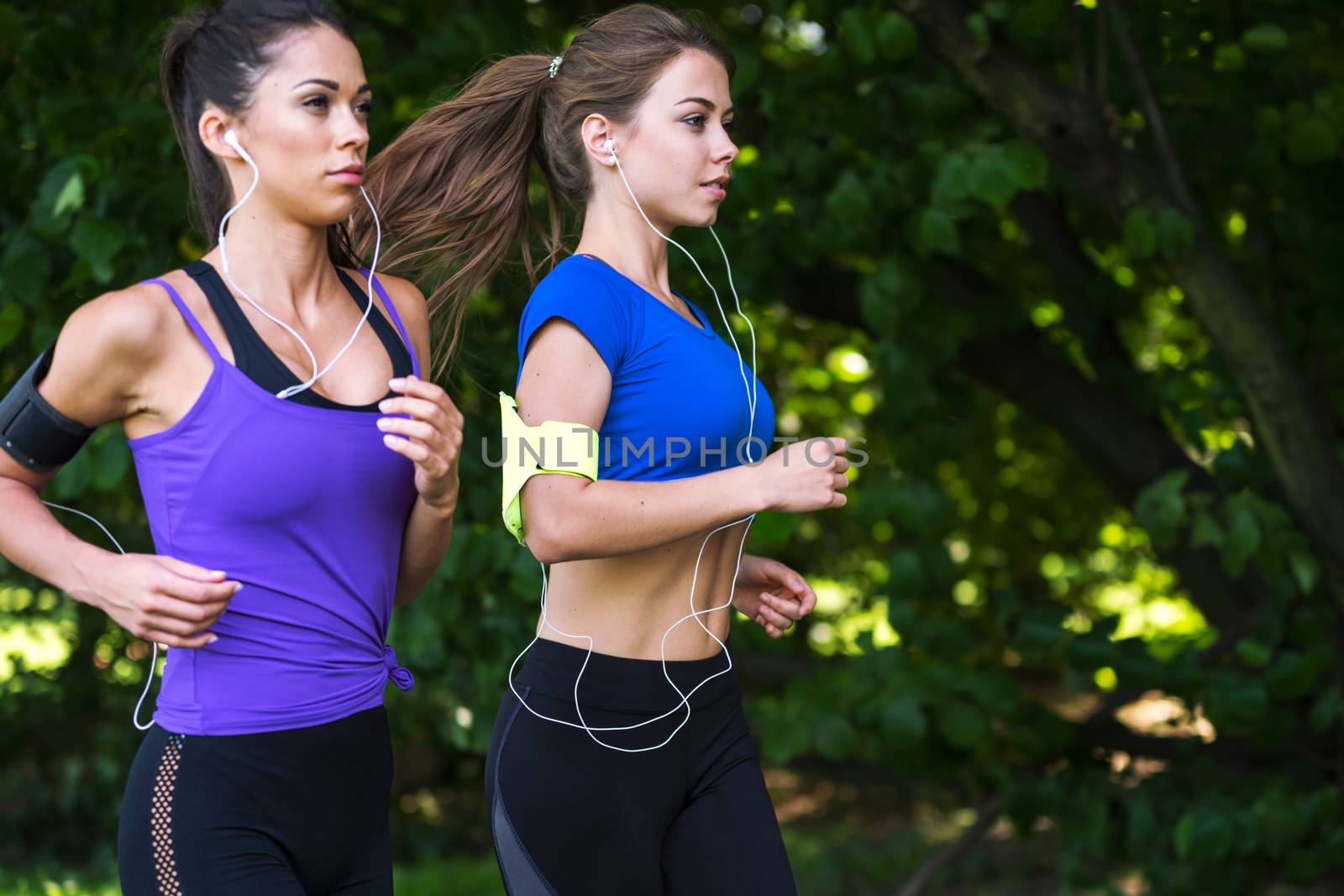 Two attractive fitness girls are jogging in the park