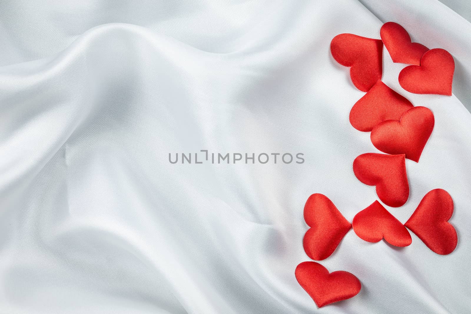 Many red hearts on a wrinkled white background detail object